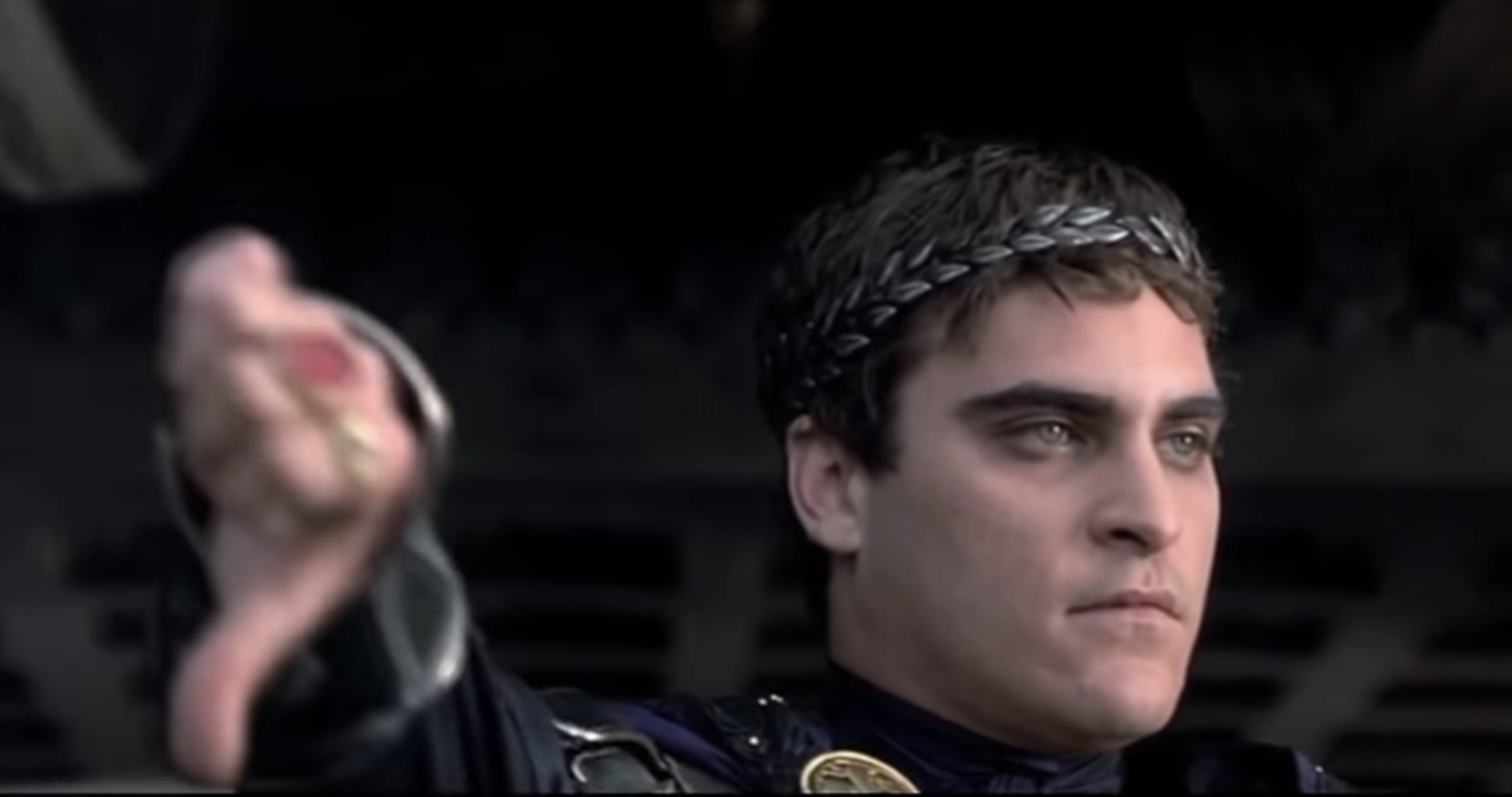 Joaquin Phoenix giving a thumbs-down as Commodus