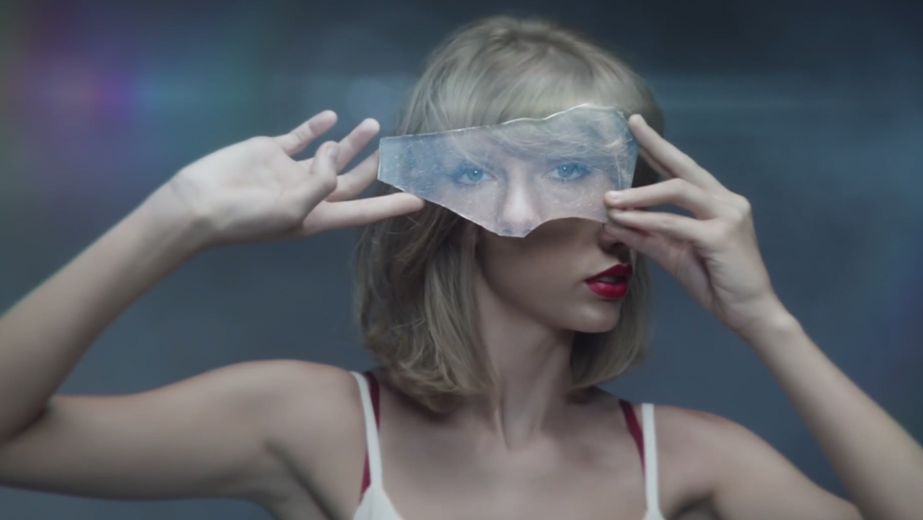 Taylor holds up a shard of mirror above her eyes, displaying a different image of her eyes, in the &quot;Style&quot; music video.