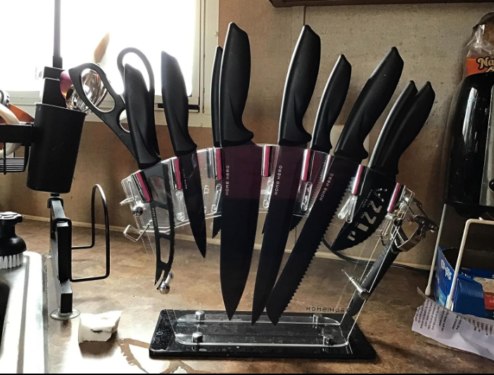 a reviewer photo of a set of black knives in a clear display knife block