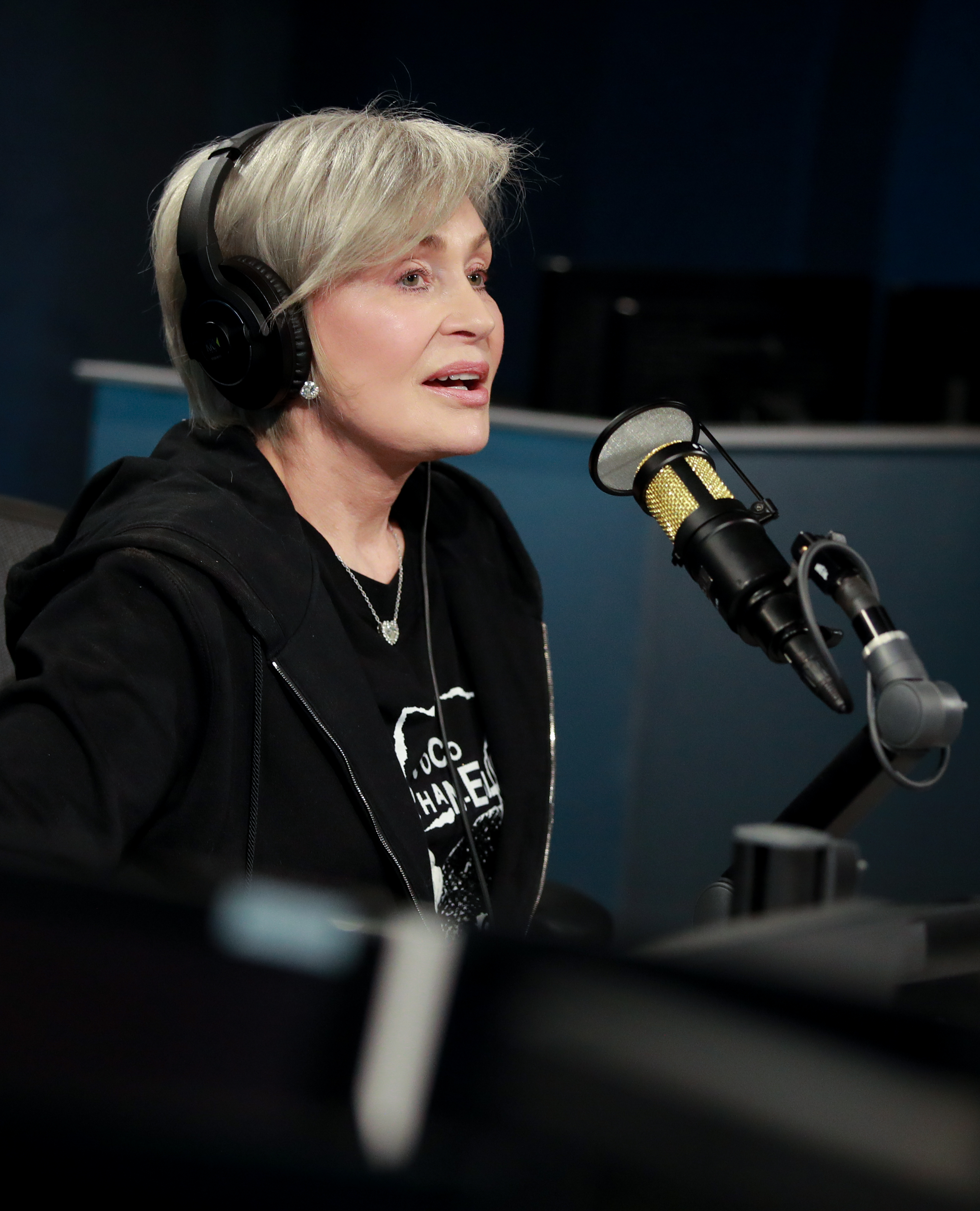 Close-up of Sharon seated and wearing headphones in front of a microphone
