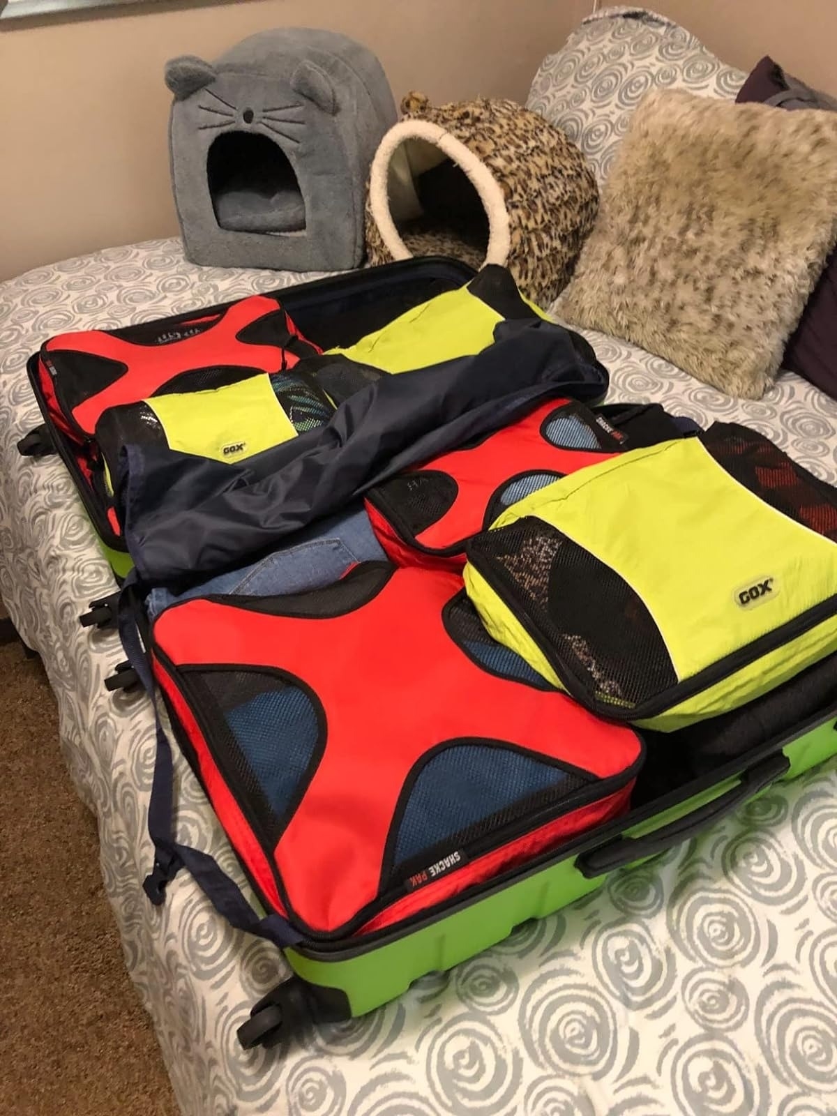 red and yellow packing cubes with clothes in a suitcase