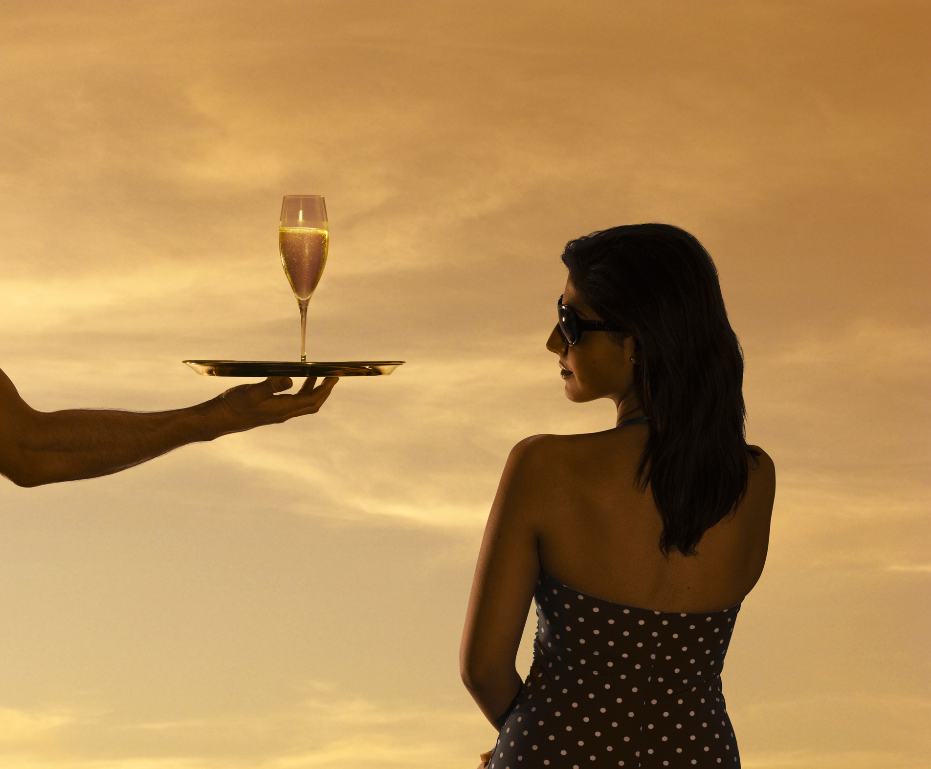 A waiter handing a woman a glass of champagne