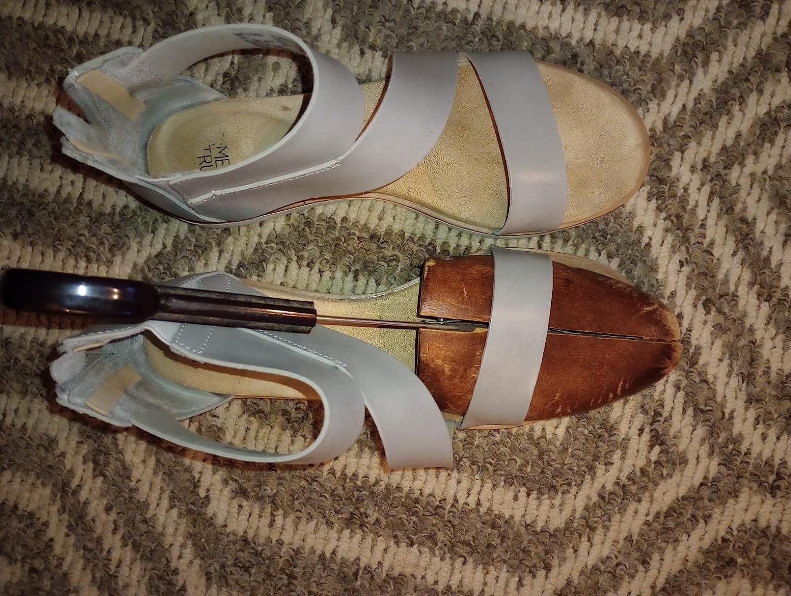 Reviewer’s photo of a pair of sandals with shoe stretcher in one of them