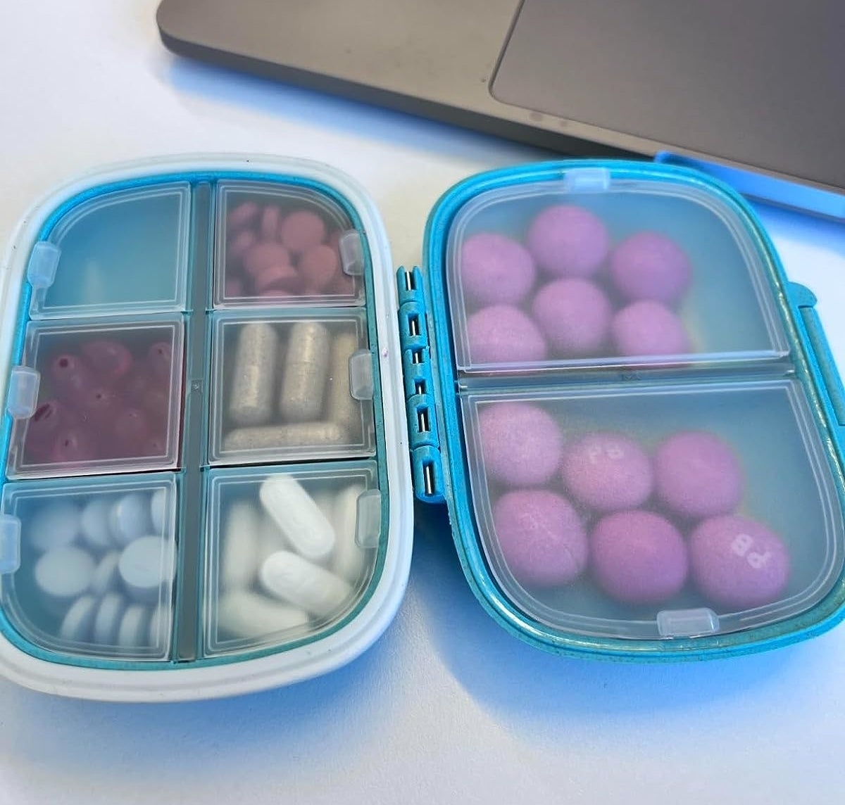 Reviewer’s photo of assorted pills inside a travel pill organizer