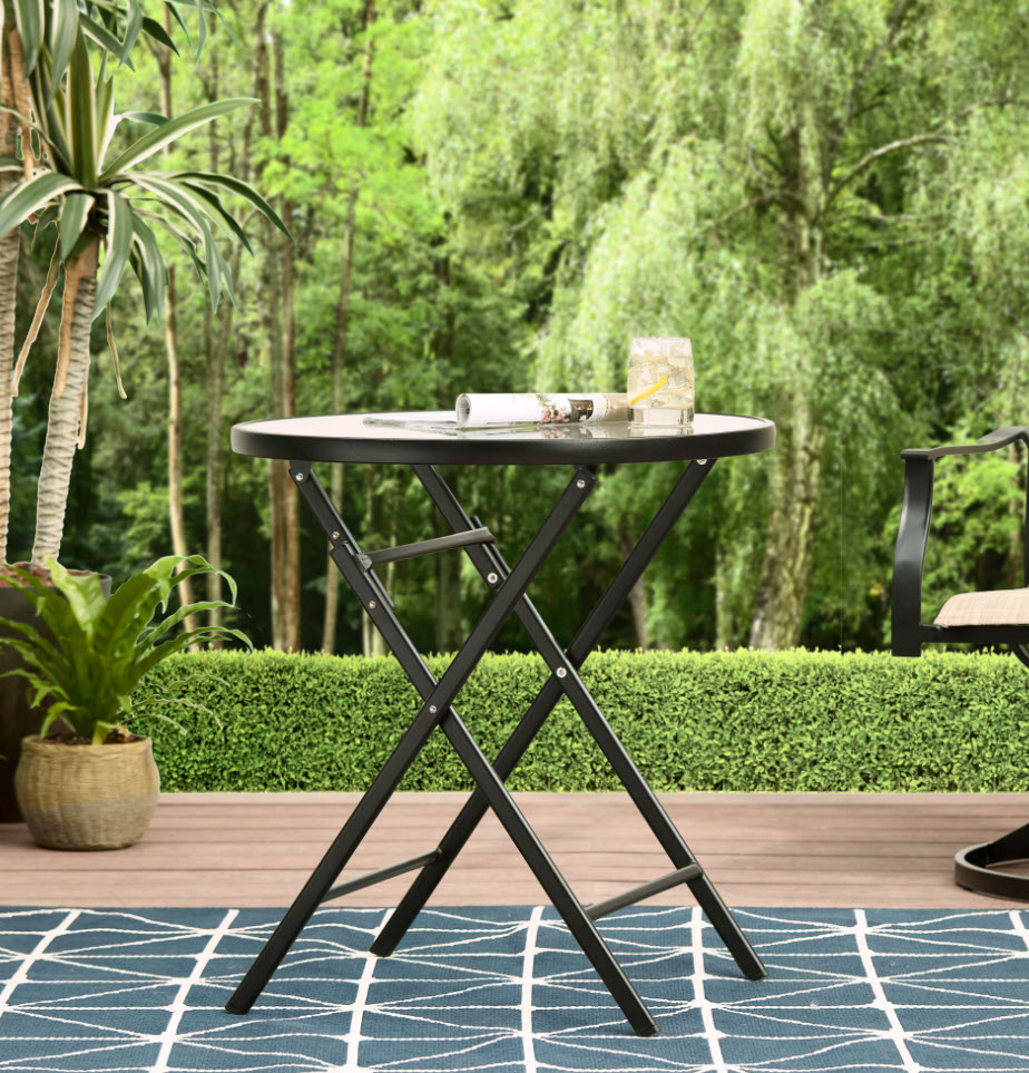 small foldable table with circular top sitting outdoors