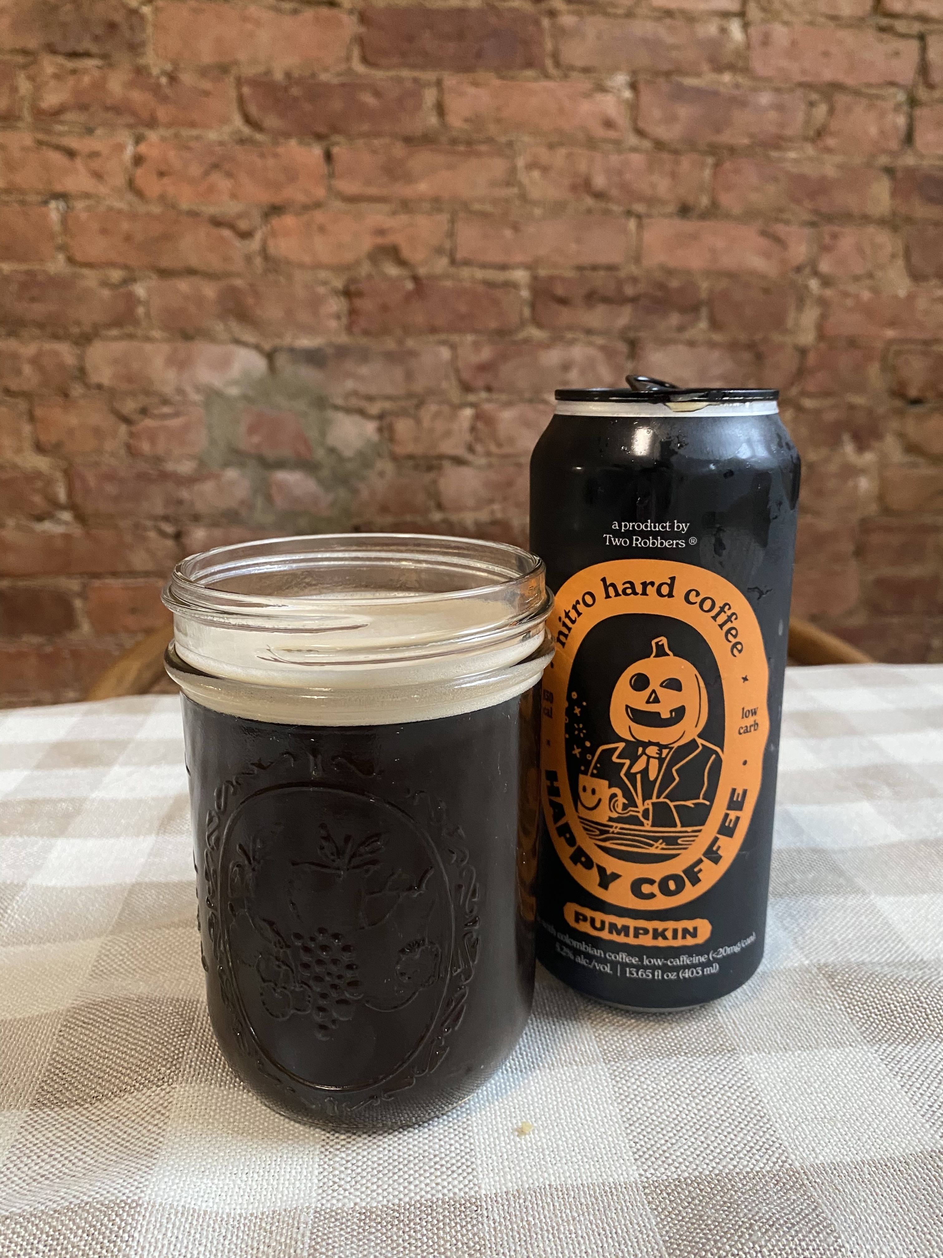 an empty can of pumpkin hard coffee next to a poured glass