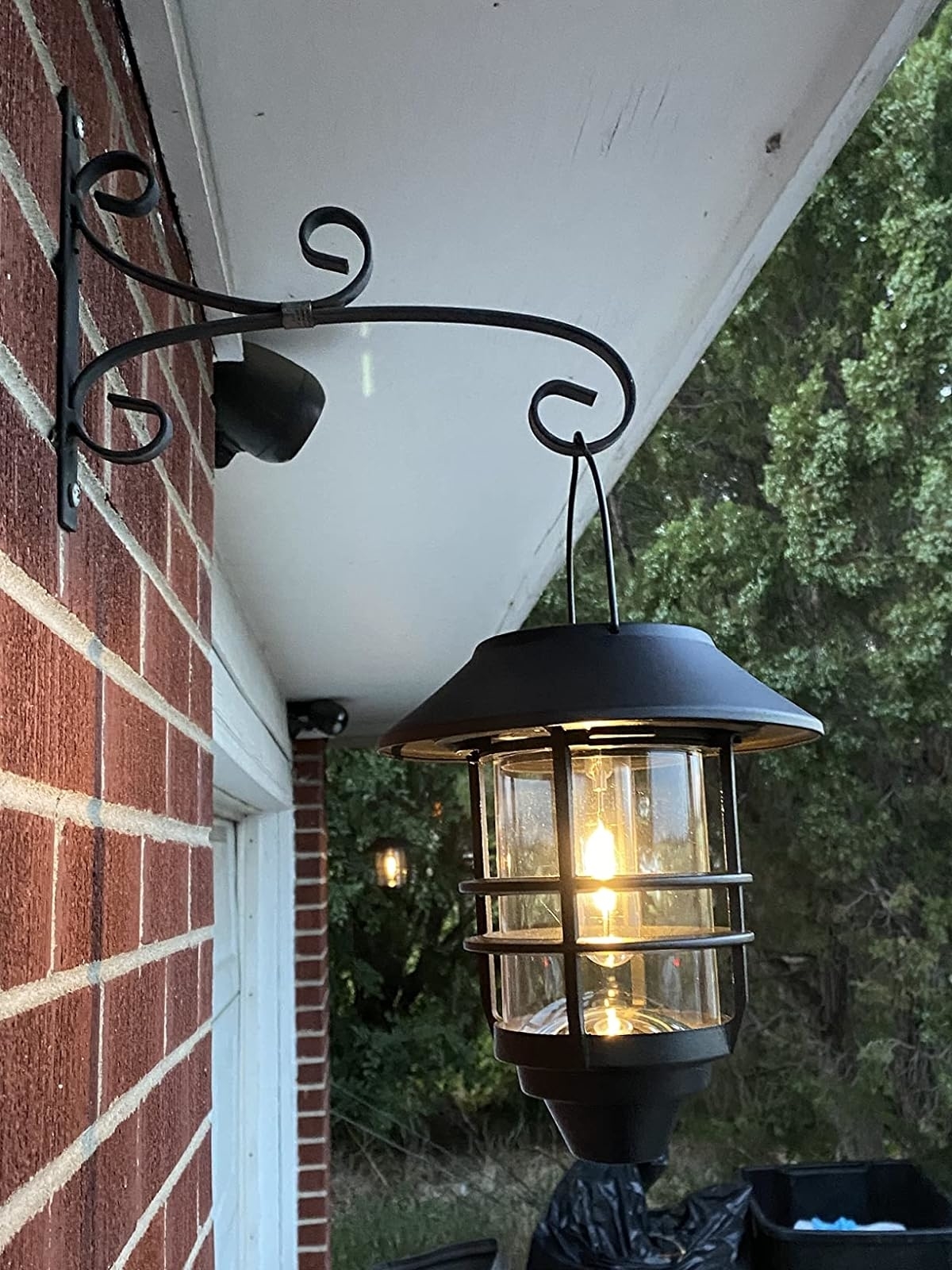 Reviewer image of the lantern hanging from a brick exterior wall