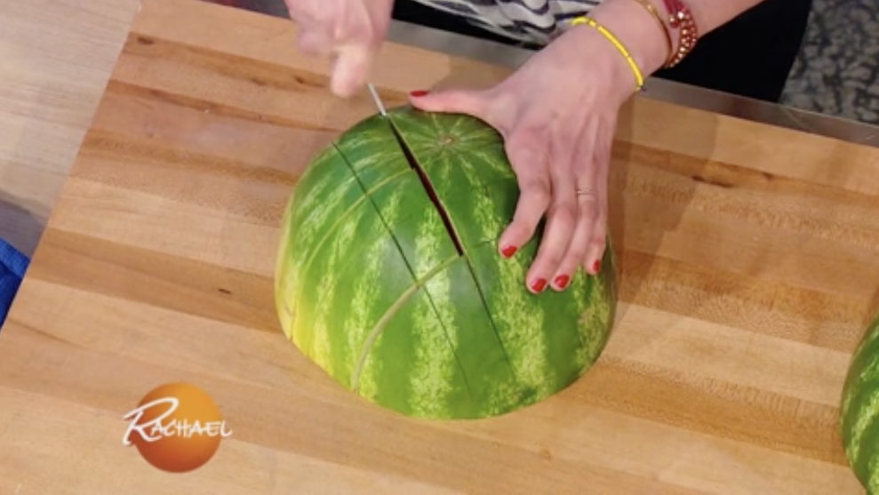 Rachael Ray is cutting a watermelon