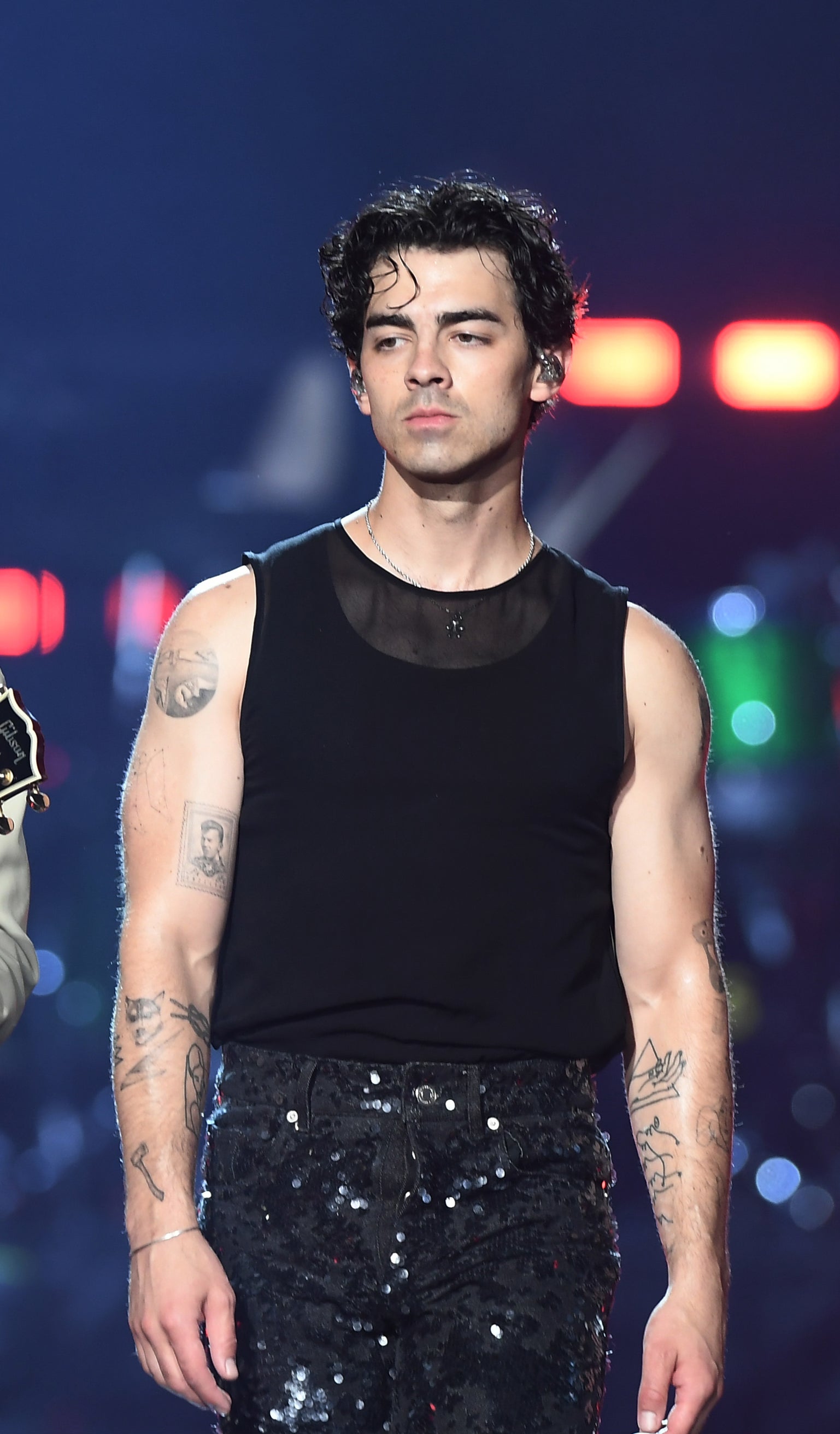 Close-up of Joe in a sleeveless tee and sparkly pants
