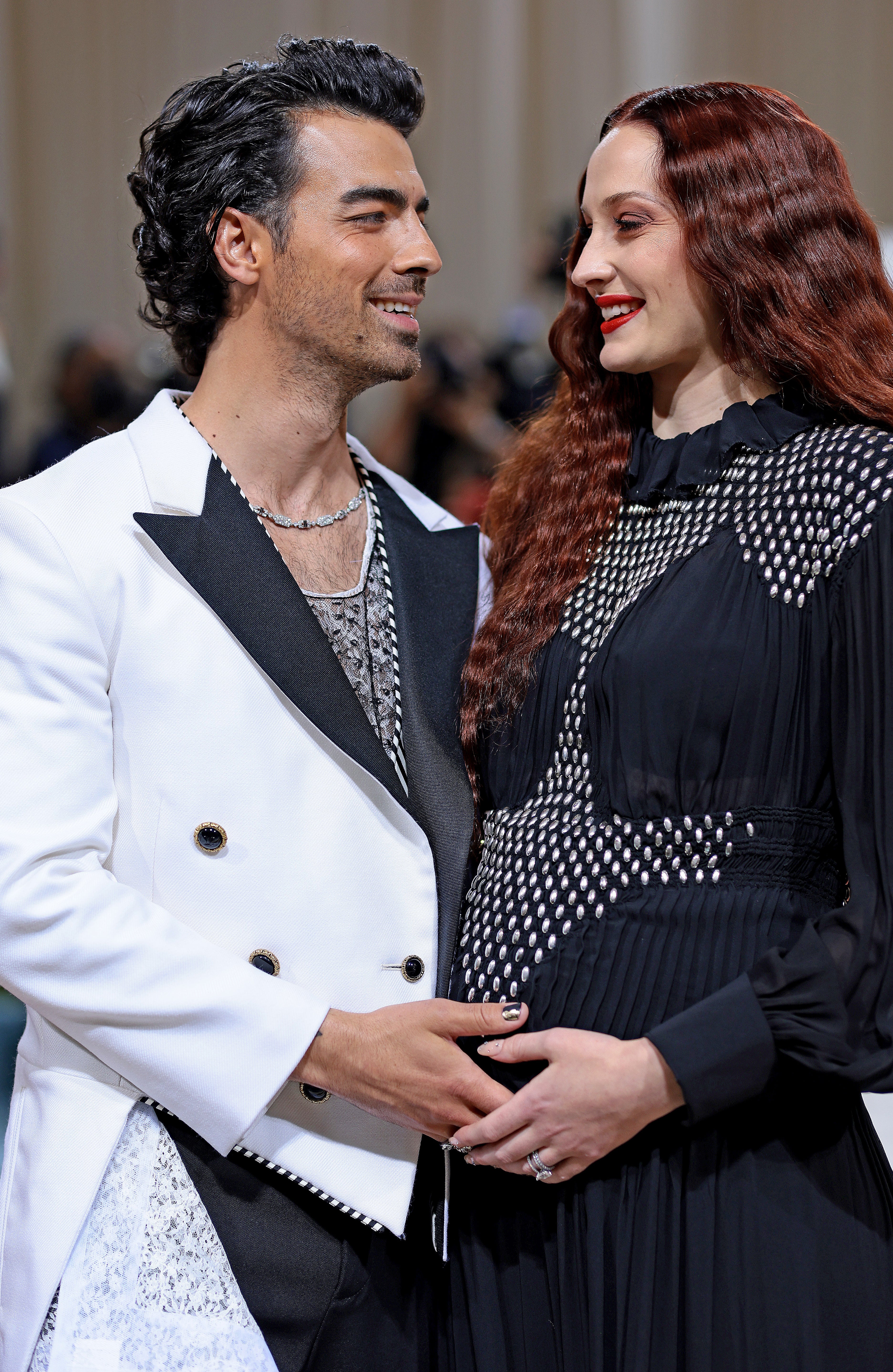 Close-up of Joe and Sophie smiling and touching each other&#x27;s hands at a media event