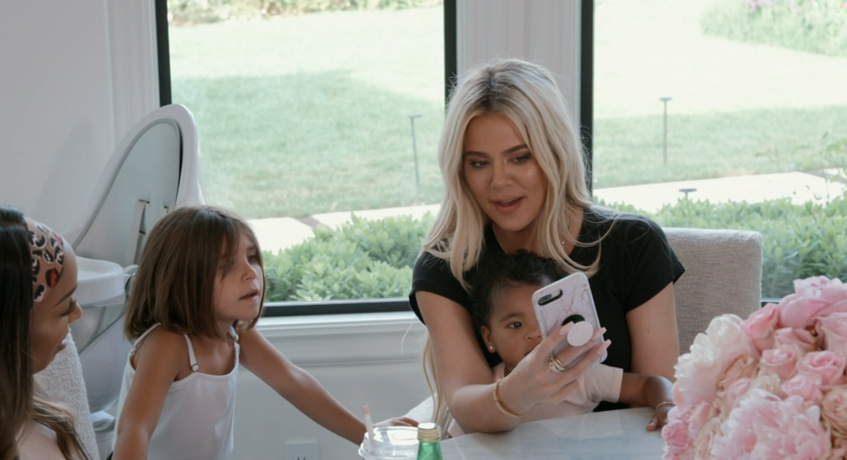 Khloé with Malika and children looking at a phone