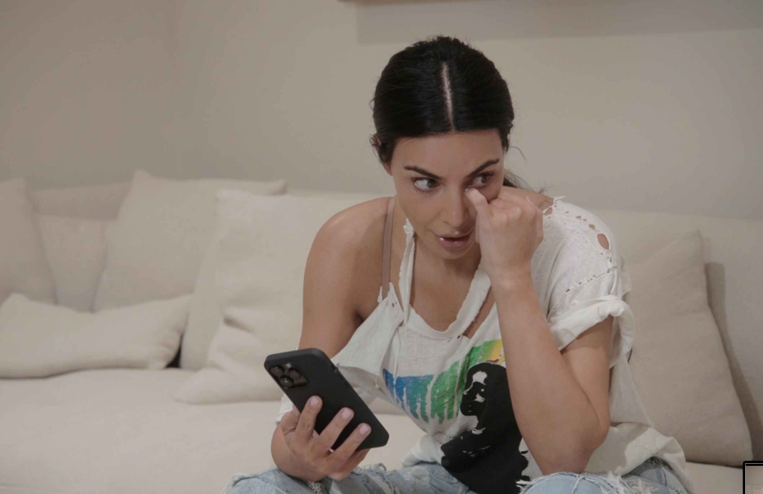 Kim sitting on a couch and holding a phone
