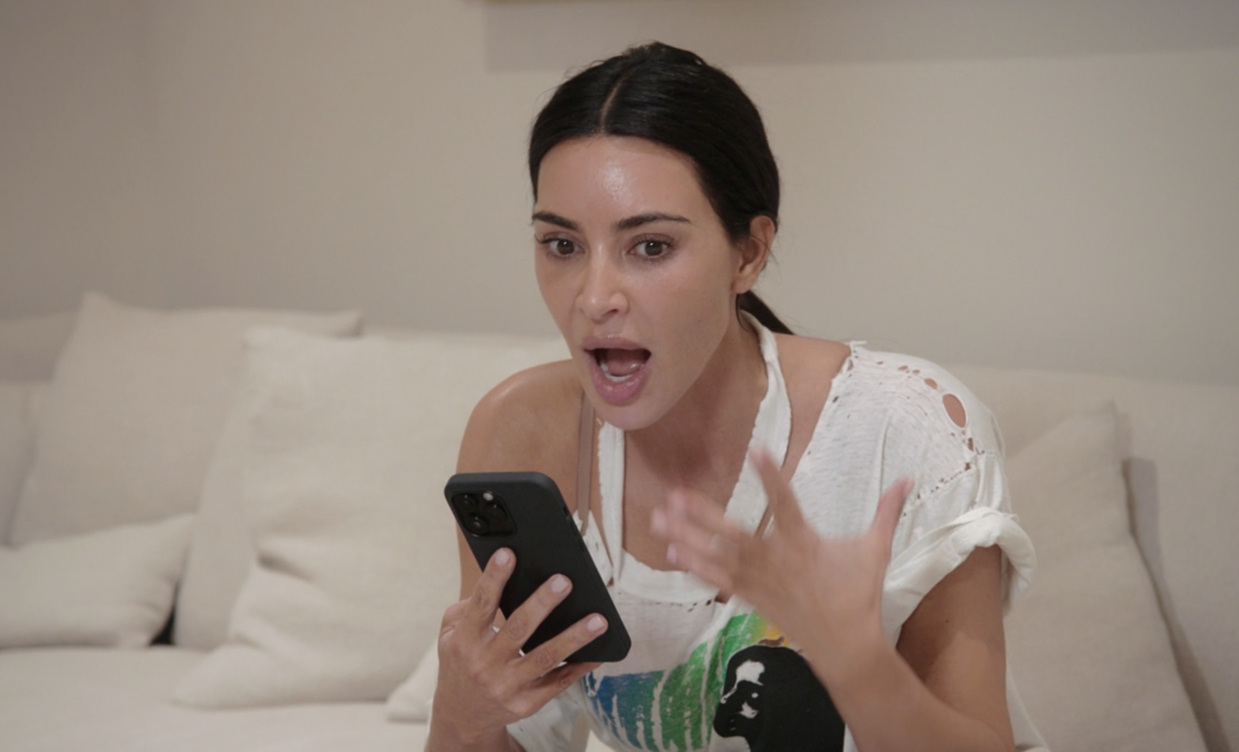 Kim sitting on a couch and talking into a phone