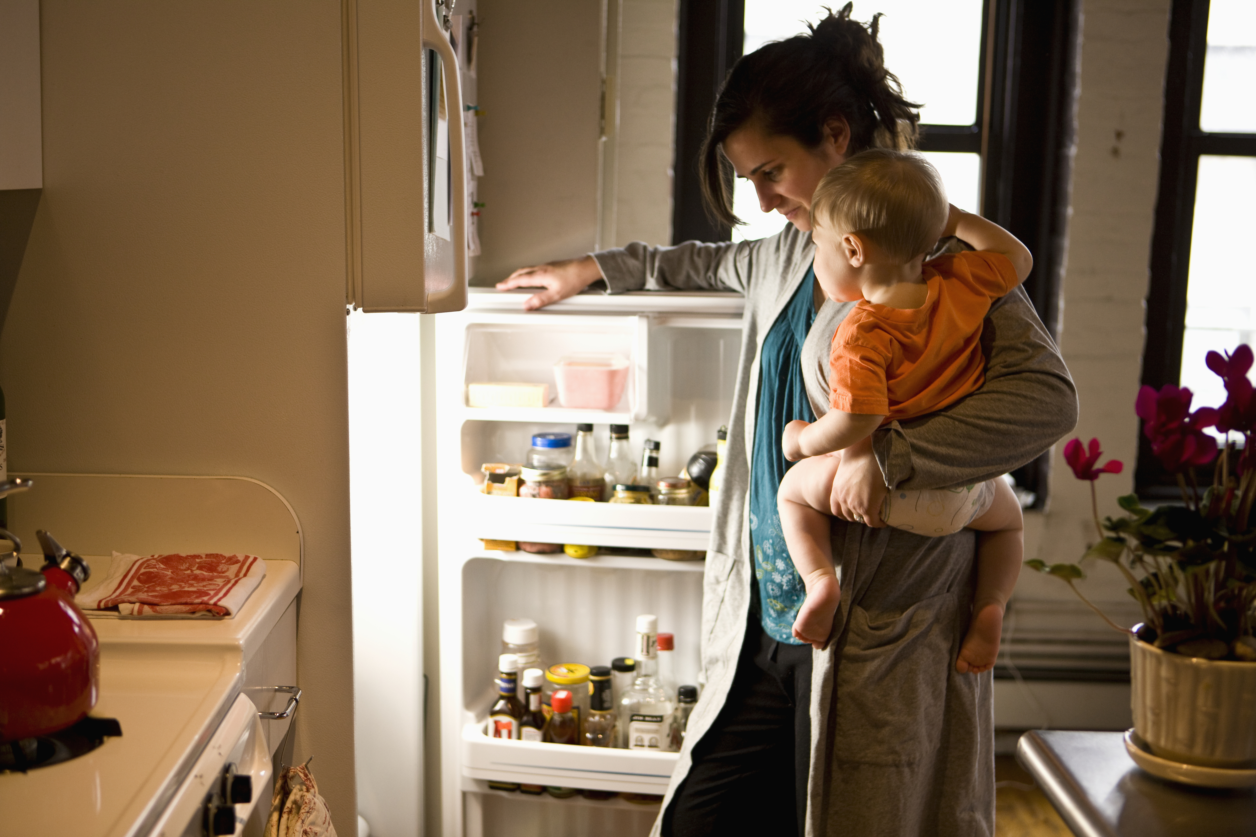 mother and child opening up a white refrigerator in the kitchen