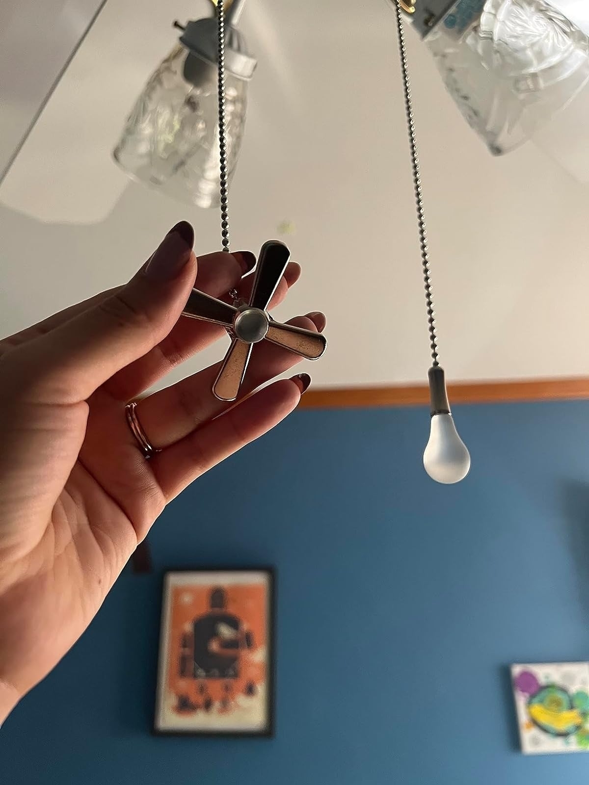 reviewer holding the ceiling fan pull chain