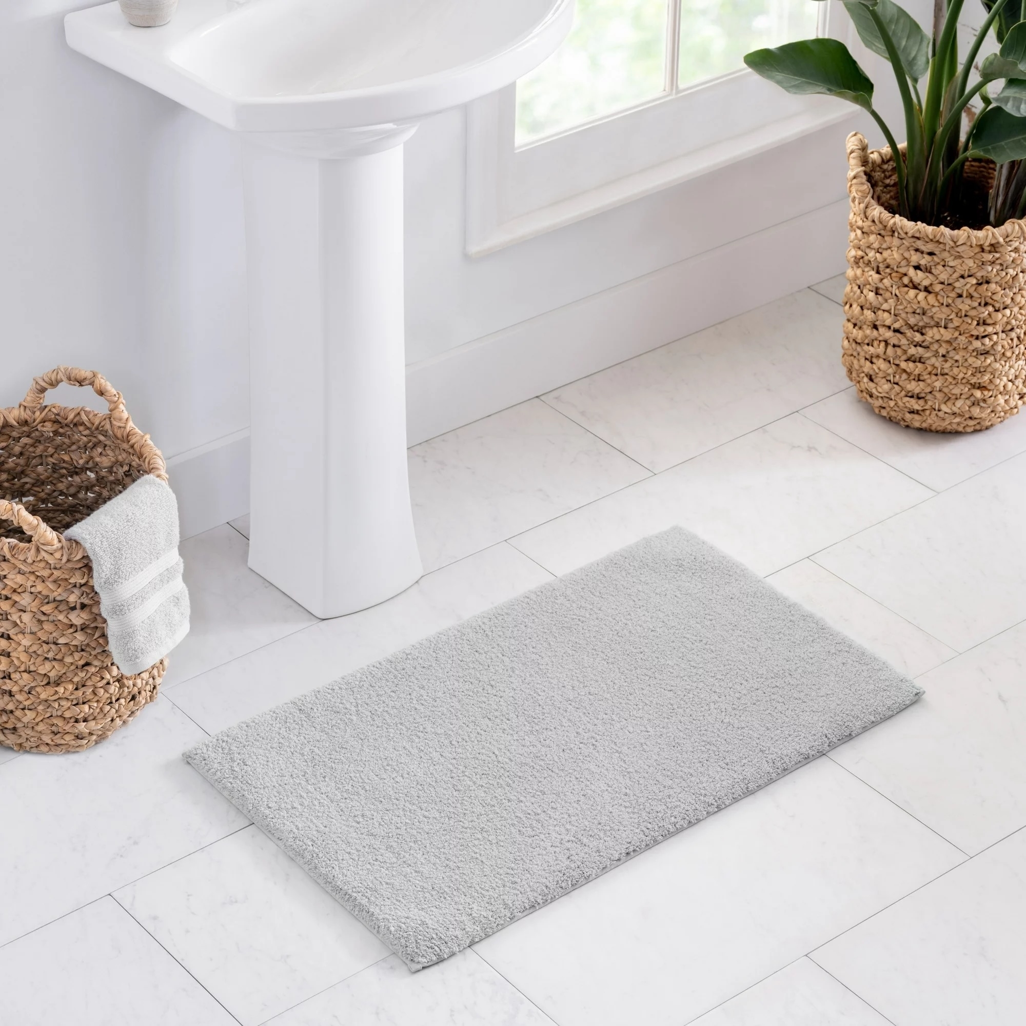 gray bath mat in front of the sink