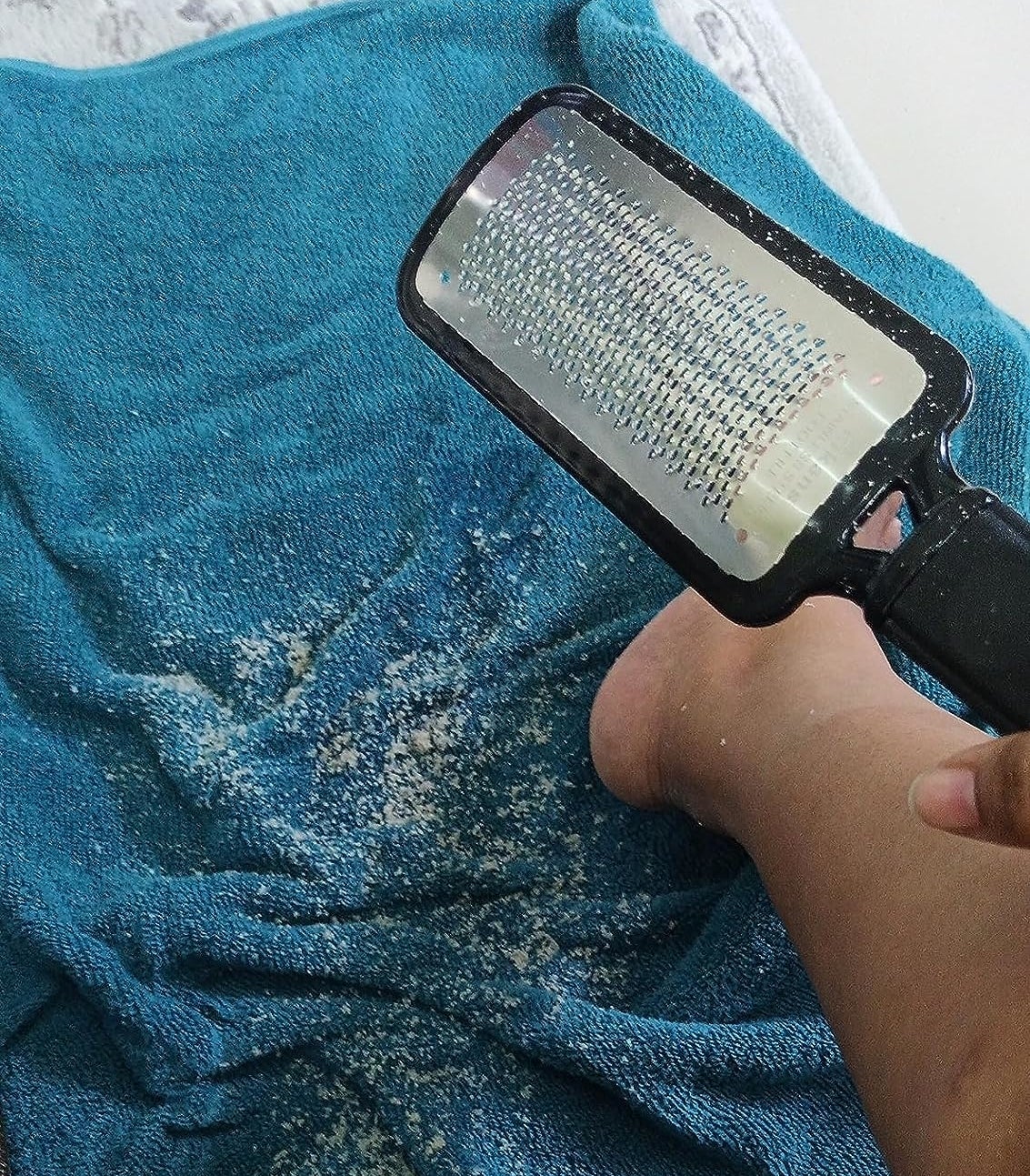Reviewer’s photo of foot file and skin flakes on a towel
