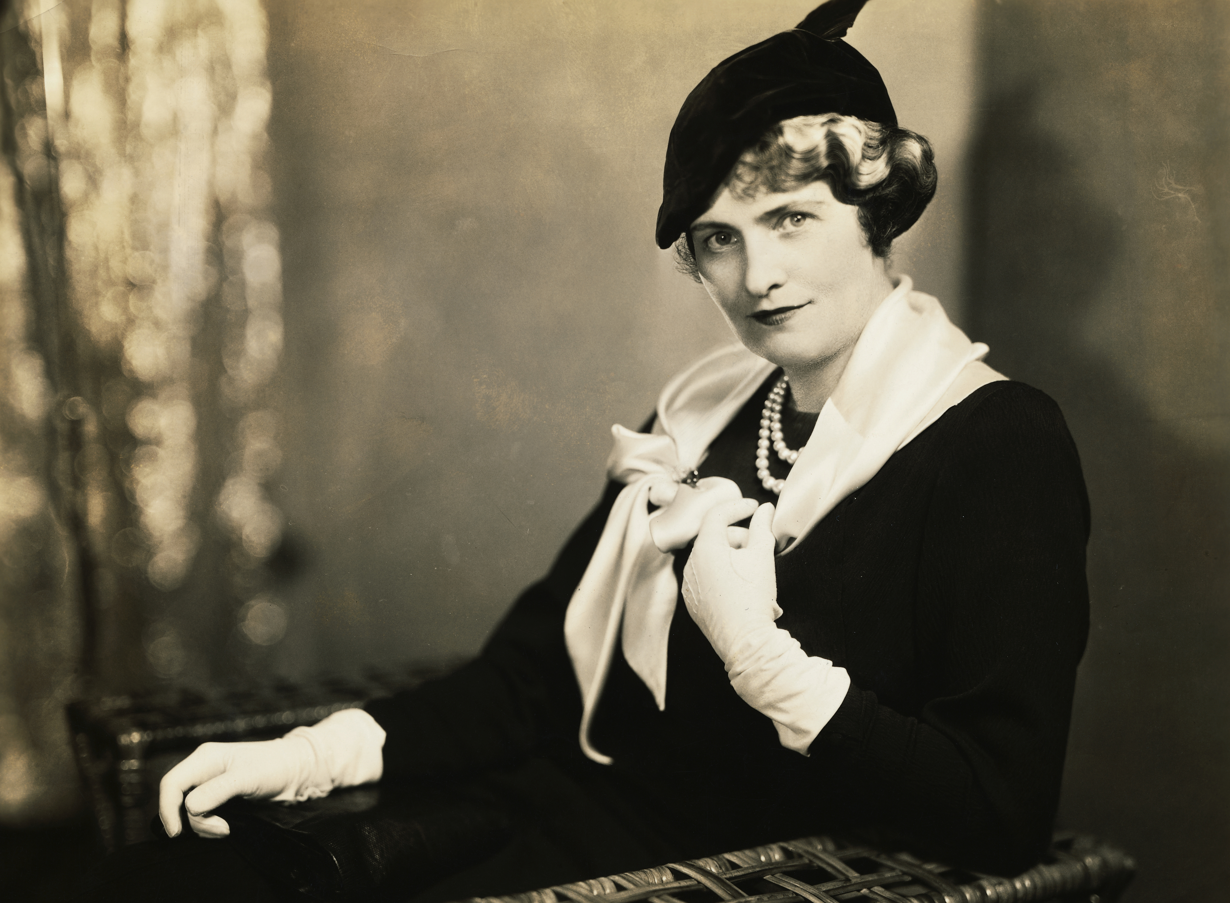 Close-up of woman wearing pearls and gloves