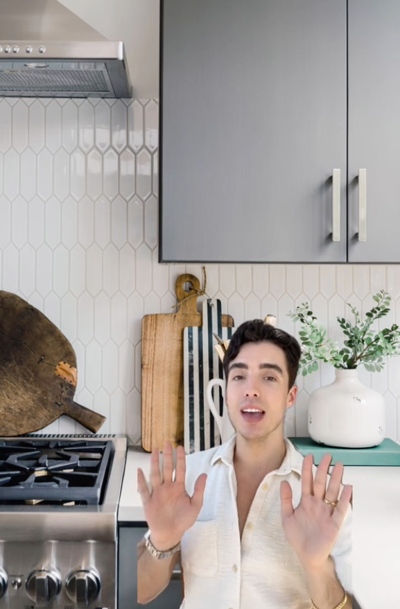 Tommy green-screened on TikTok in front of a kitchen with peel and stick tile backsplash