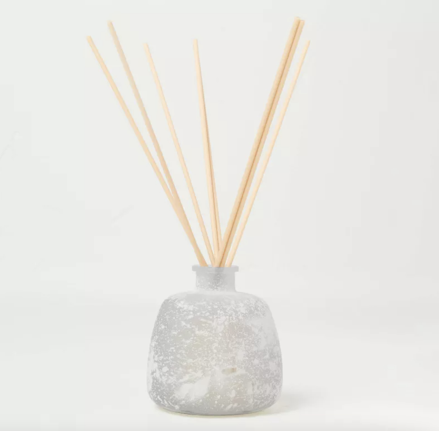 a frosted glass aromatherapy diffuser with wooden diffuser sticks