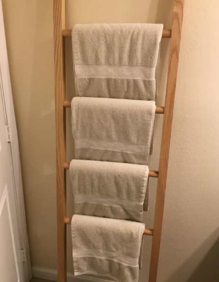 DIY ladder in bathroom for hanging towels against the wall