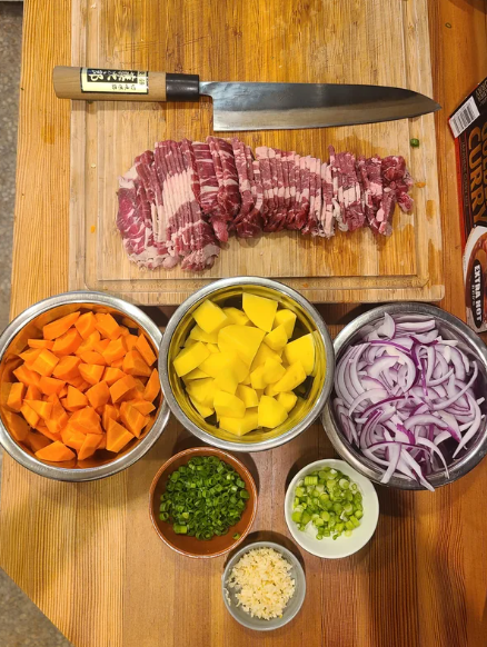 mise en place with veggies, steak, and other ingredients