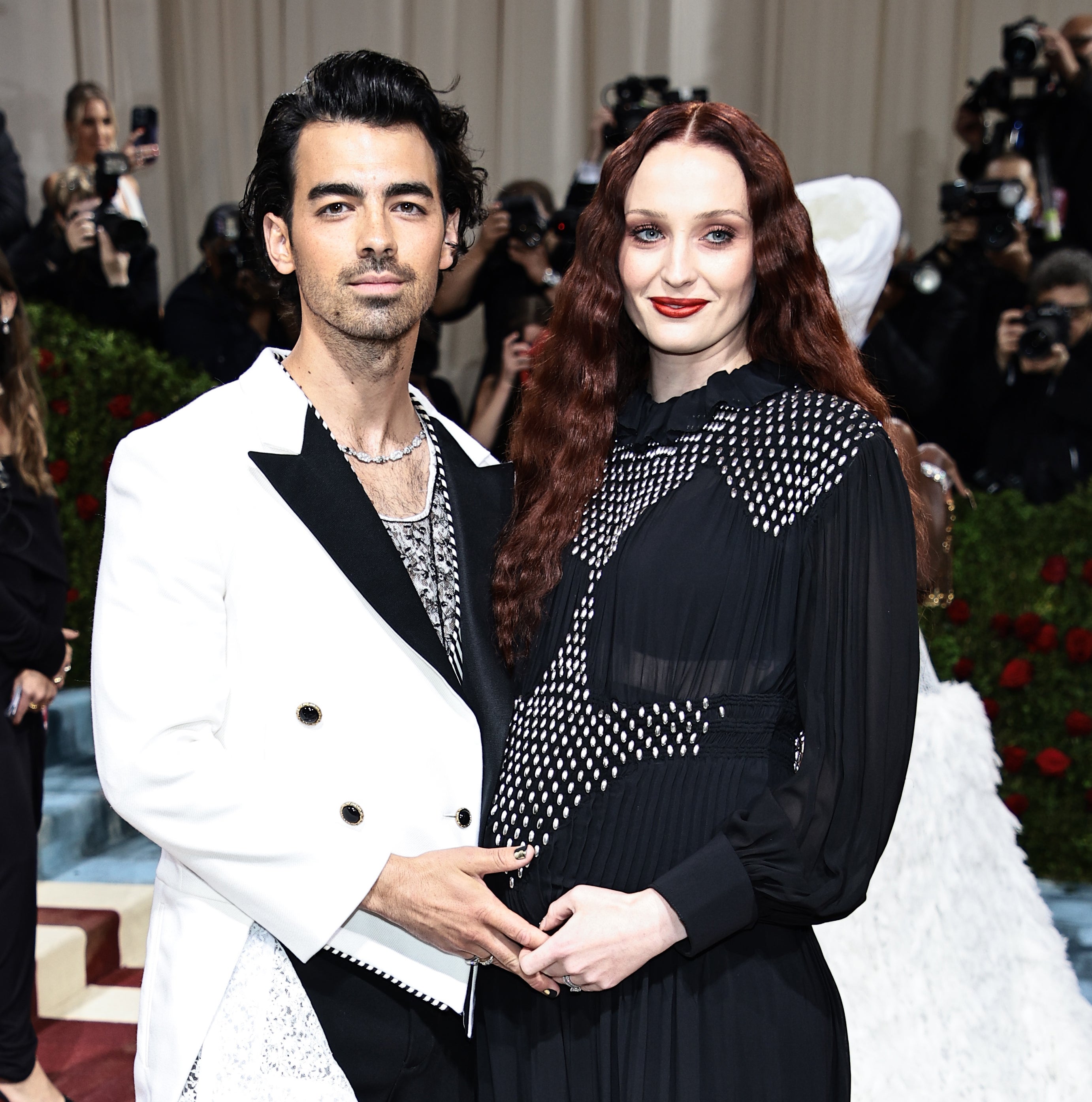 the two holding the baby bump at the met