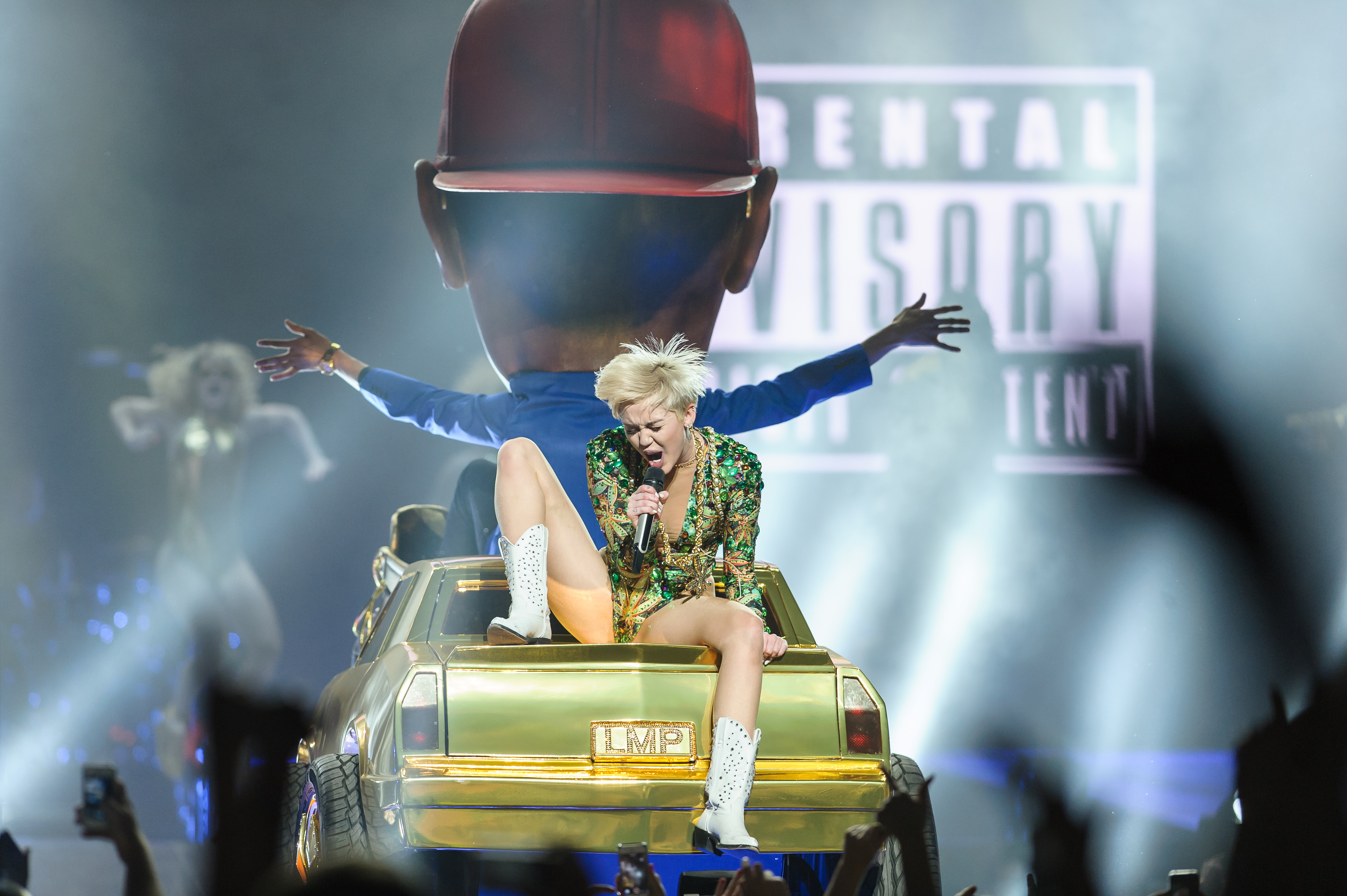 miley singing in the back of a car on stage