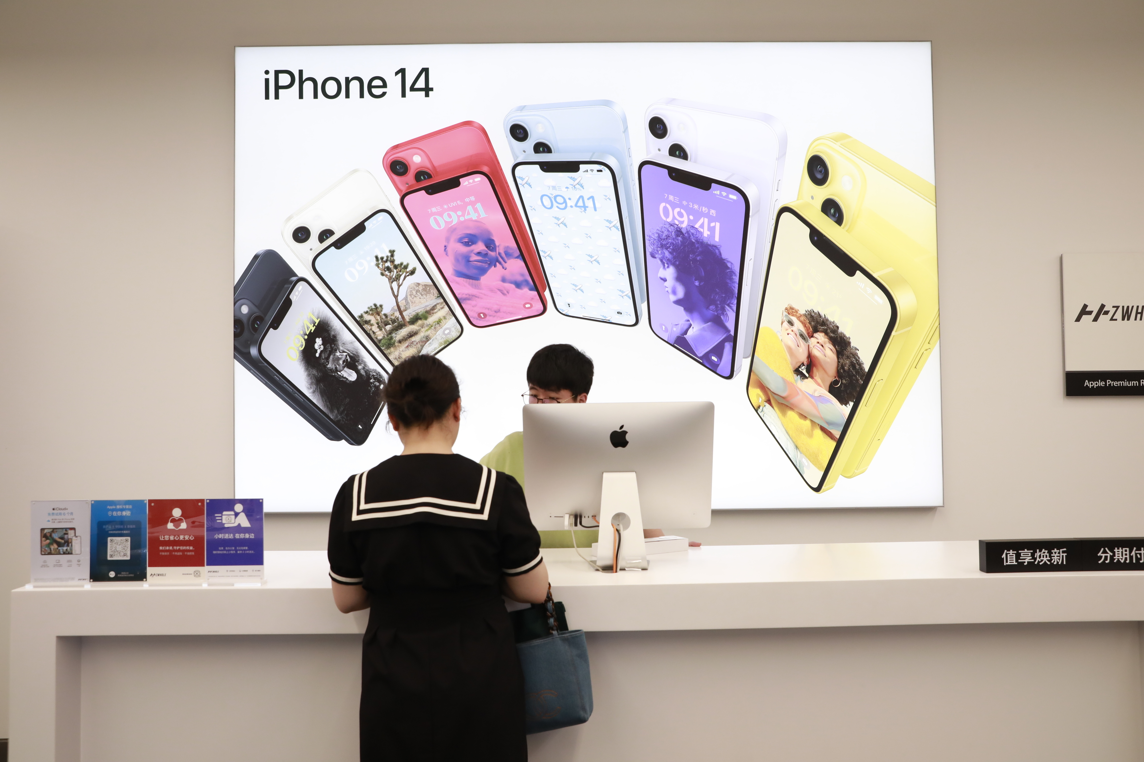 a person standing at a register in an apple store