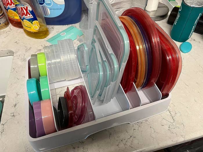 Reviewer image of different sized and colored lids inside the organizer