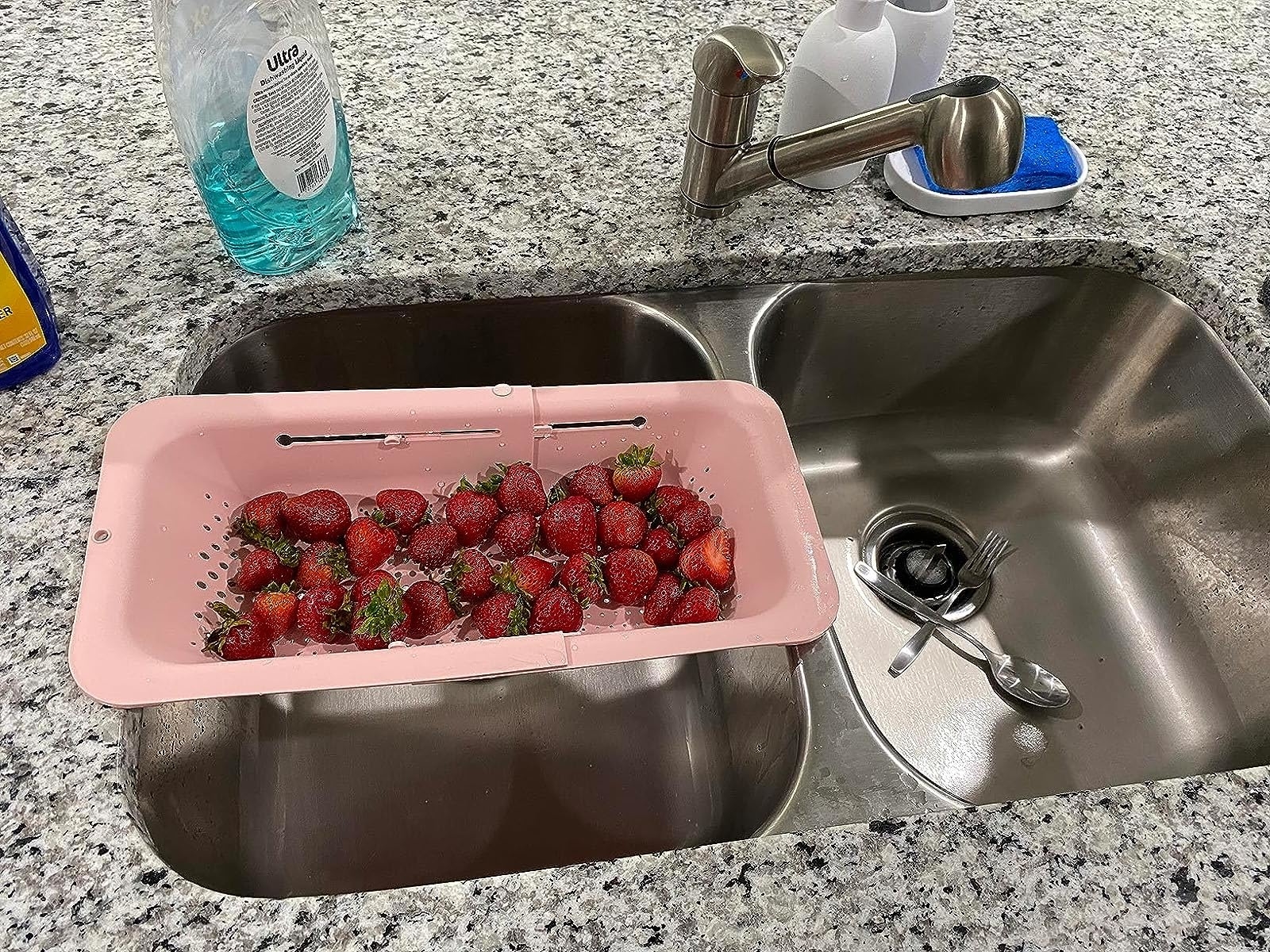 reviewer image of the pink strainer over a sink with strawberries in it
