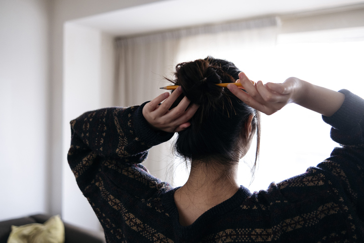 person putting their hair up in a bun