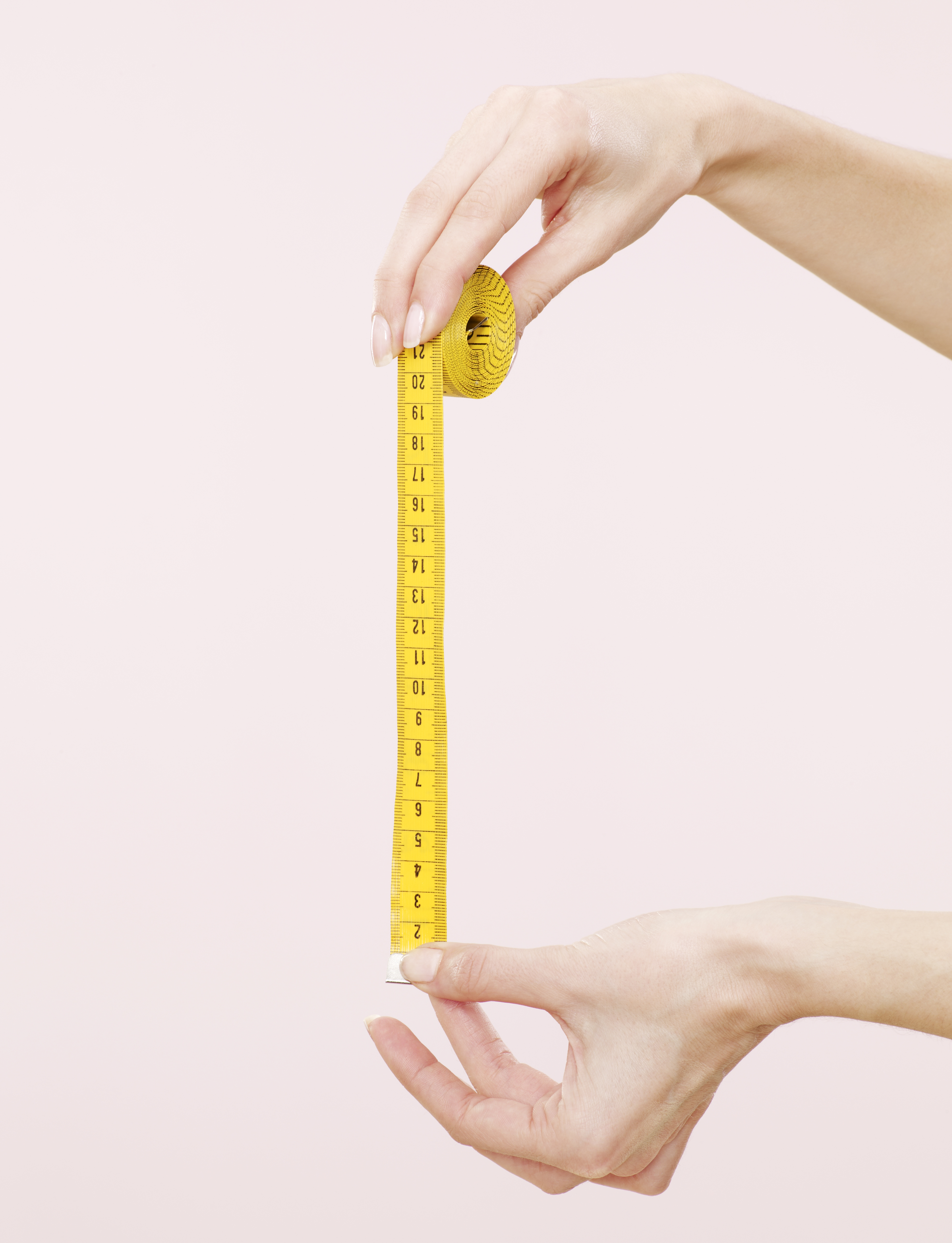 person holding measuring tape that uses inches