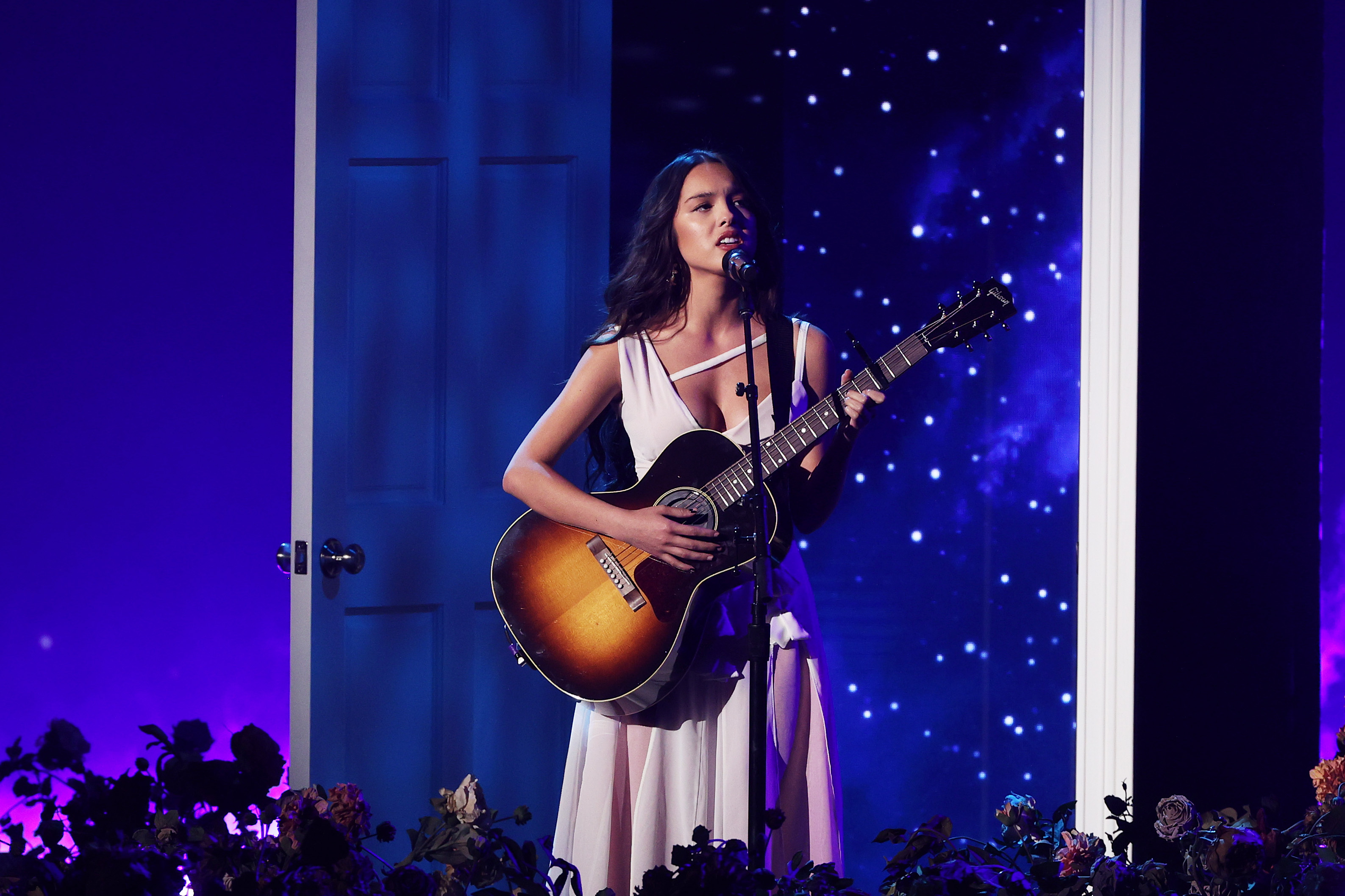 Olivia performing with a guitar