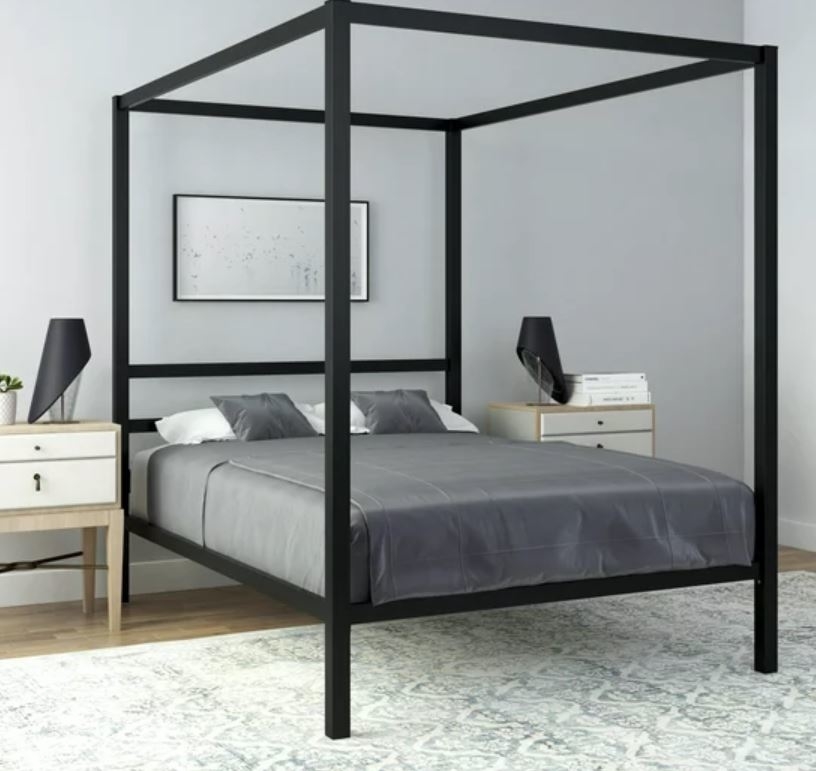 black canopy bed frame with made bed in bedroom