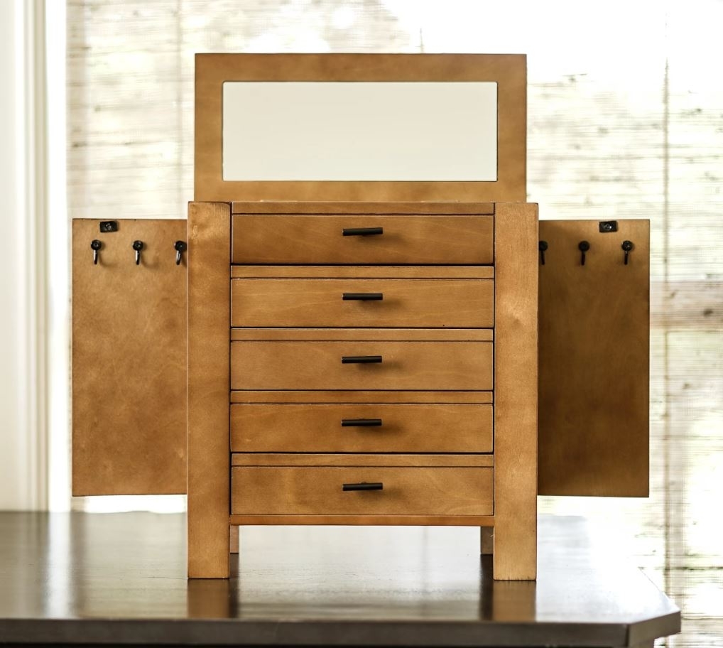 open jewelry with multiple small drawers and hooks with open top mirror
