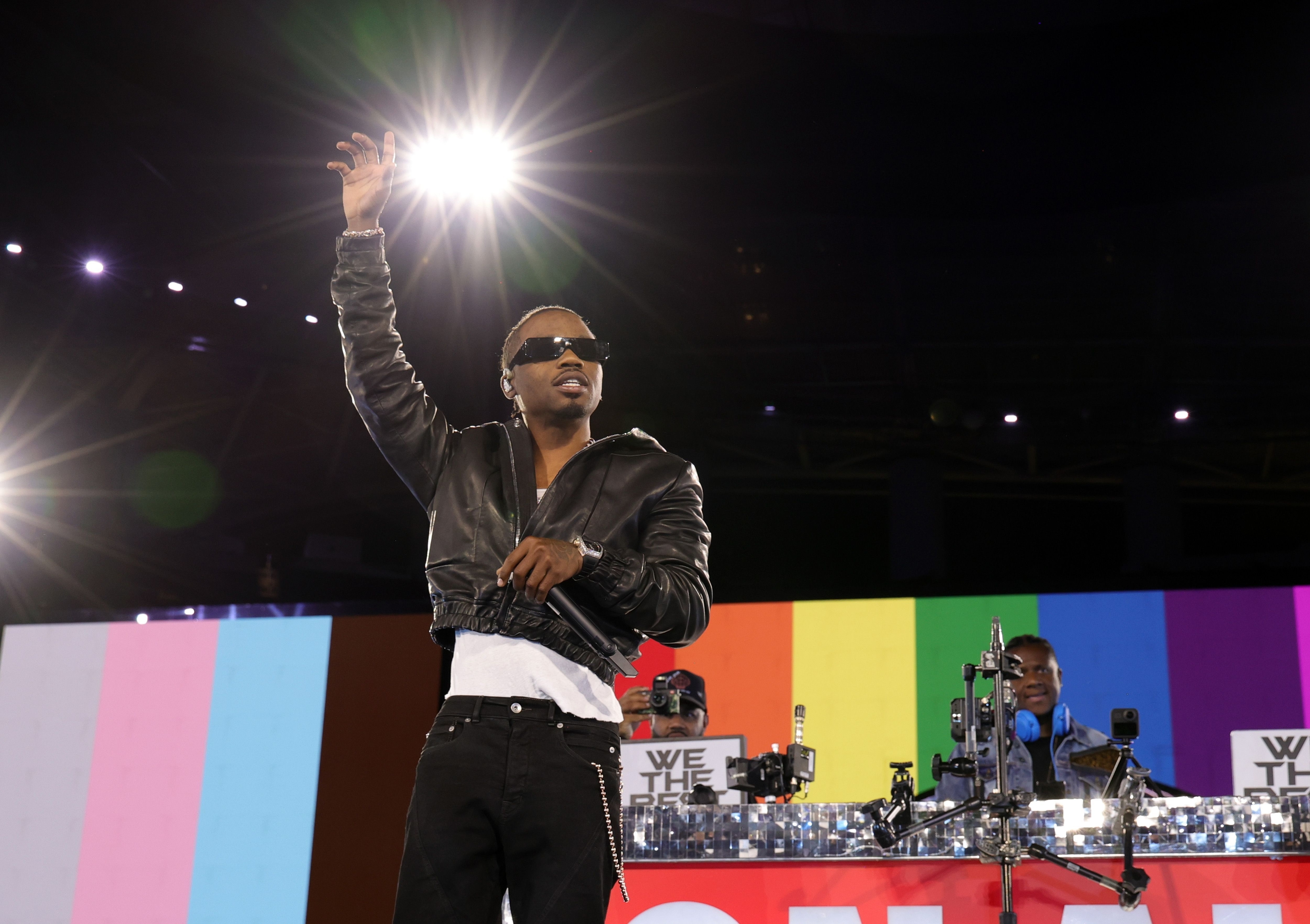 Roddy Ricch onstage with his arm raised