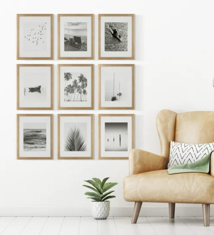 set of nine wooden frames hanging on wall next to accent chair