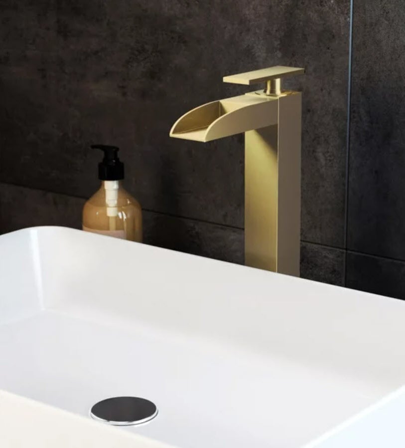 gold waterfall faucet over sink