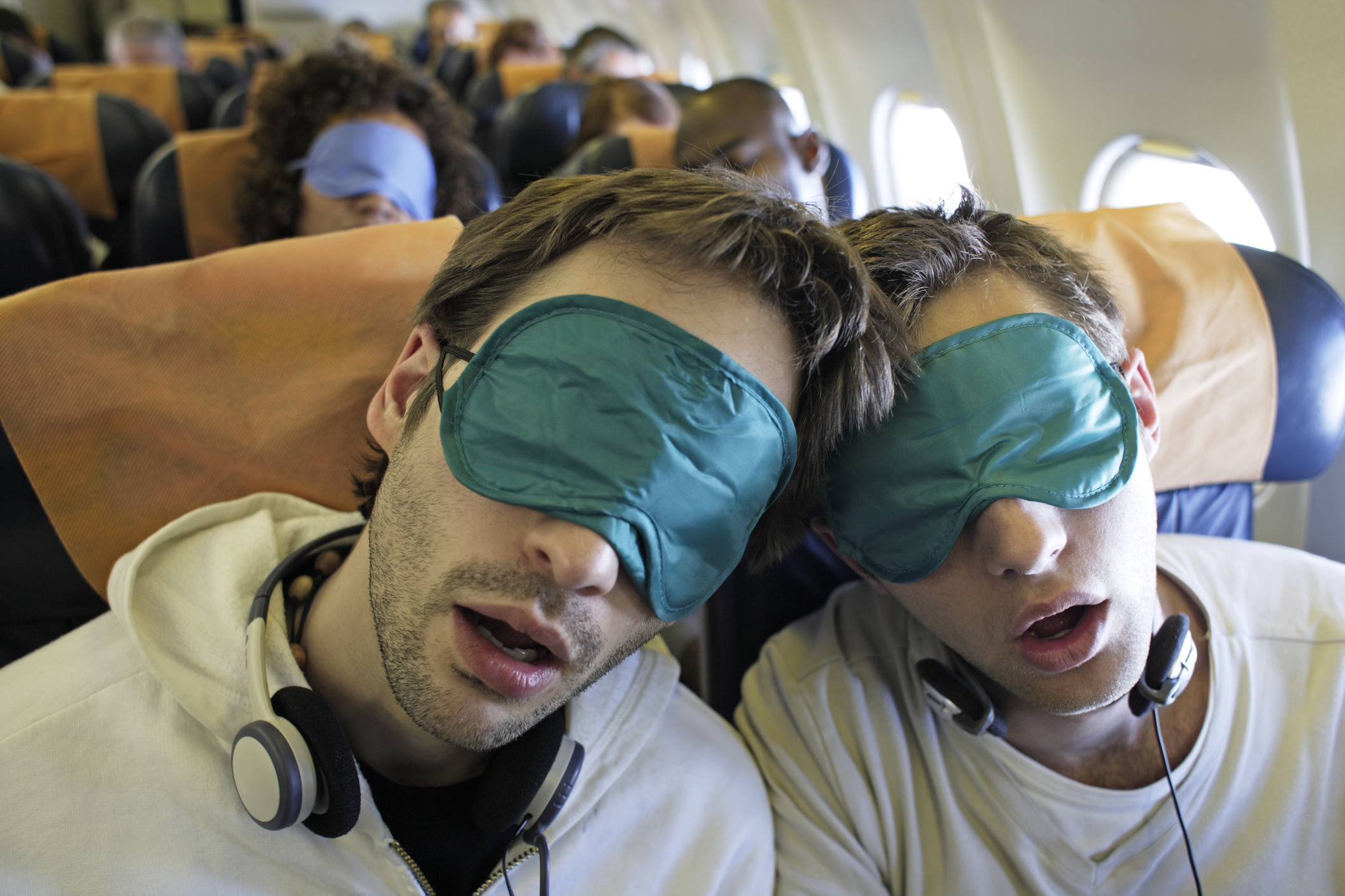 Two people sleeping on a plane