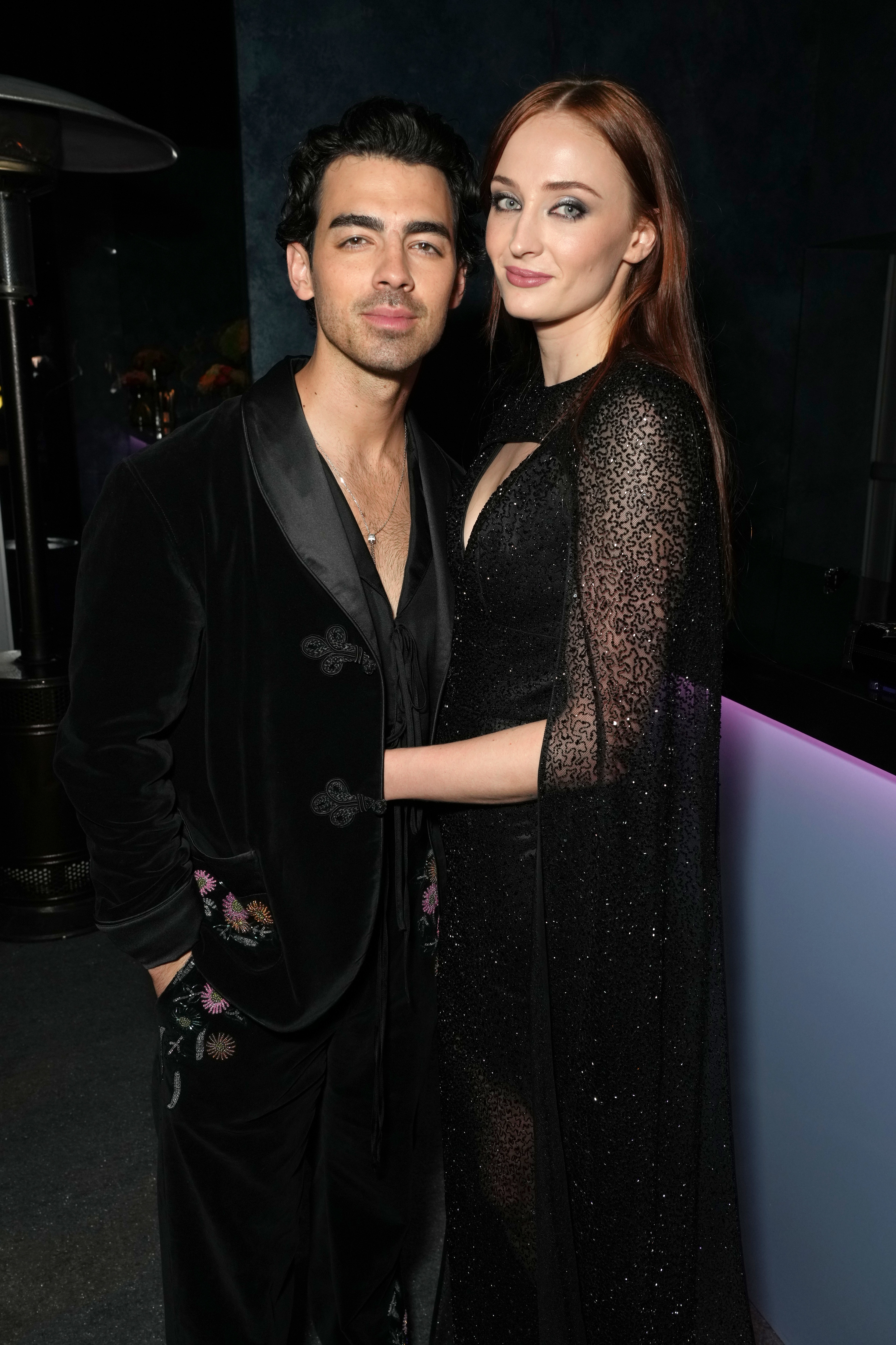 sophie turner with her arms around joe jonas at an event