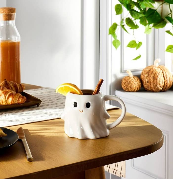 The white, ghost-shaped mug with a smiley face and a handle