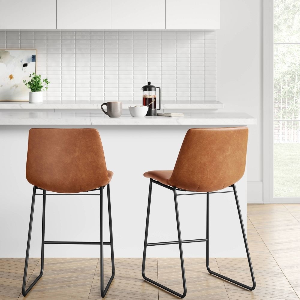 Two brown stools at a counter
