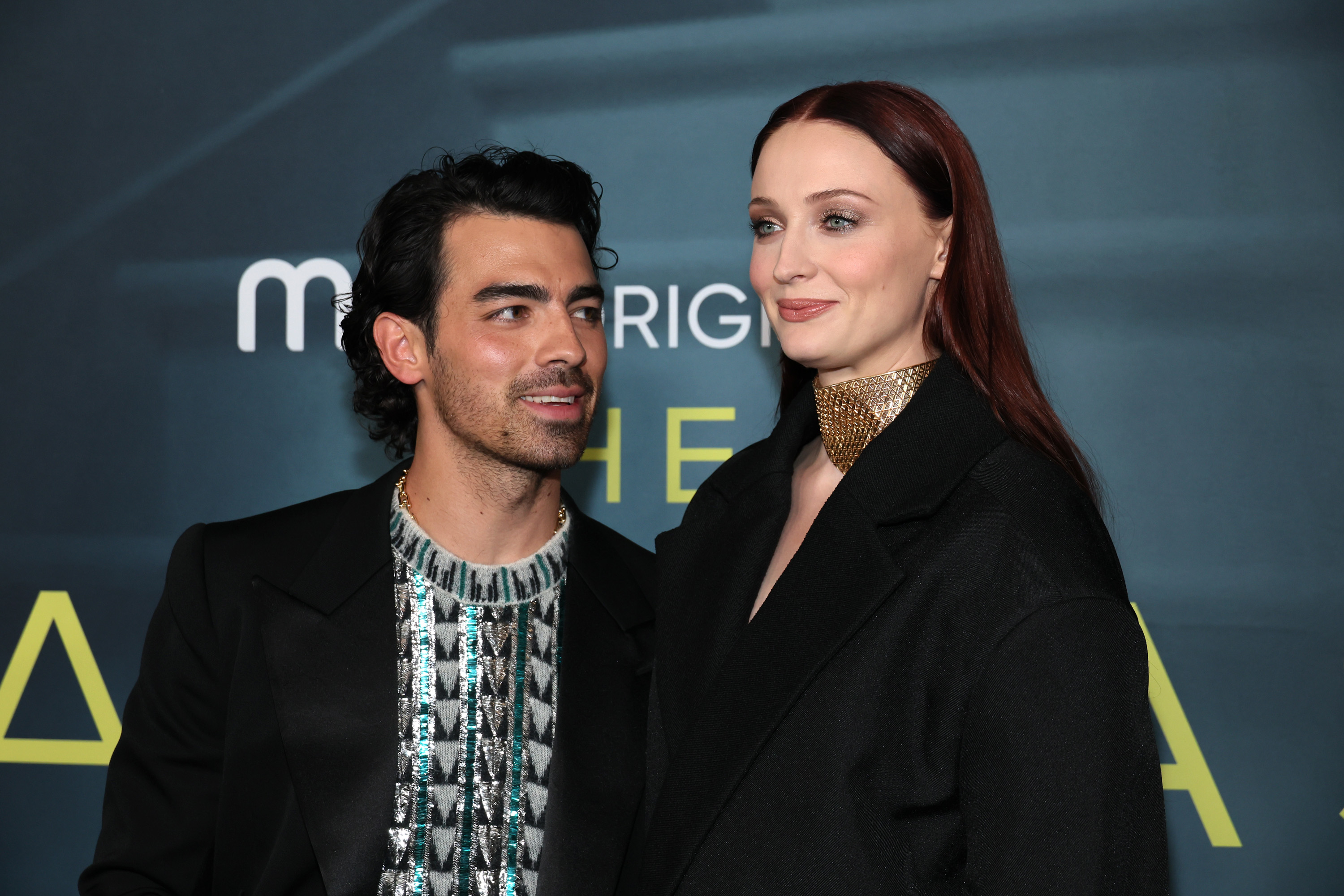 Joe smiles as he looks at Sophie Turner on the red carpet