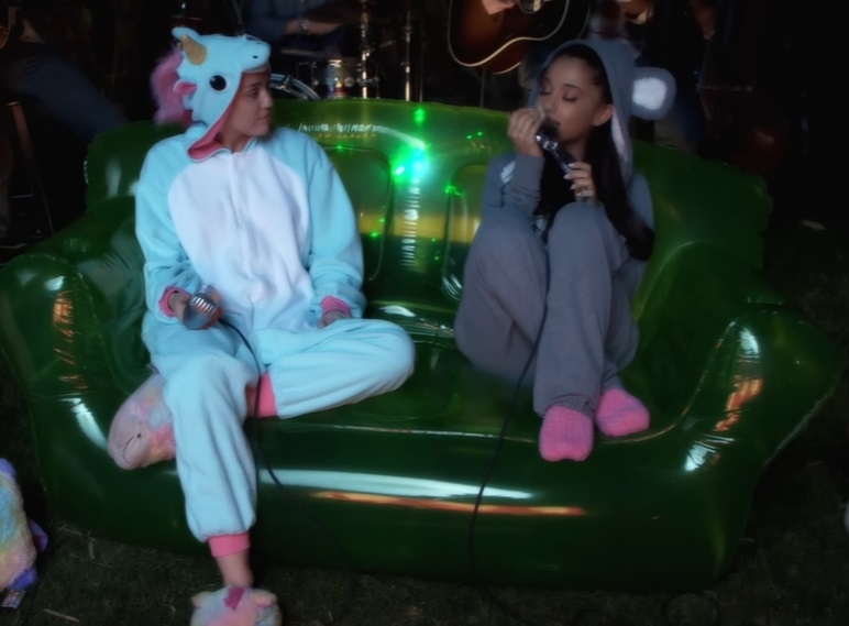 Miley and Ariana wearing onsesies as they sit aad perform