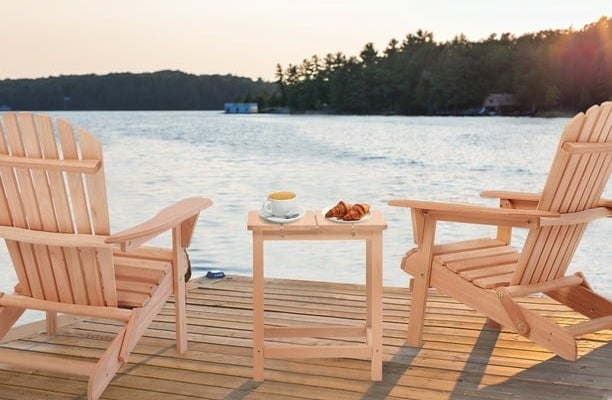 two of the rose gold chairs on a dock overlooking a body of water