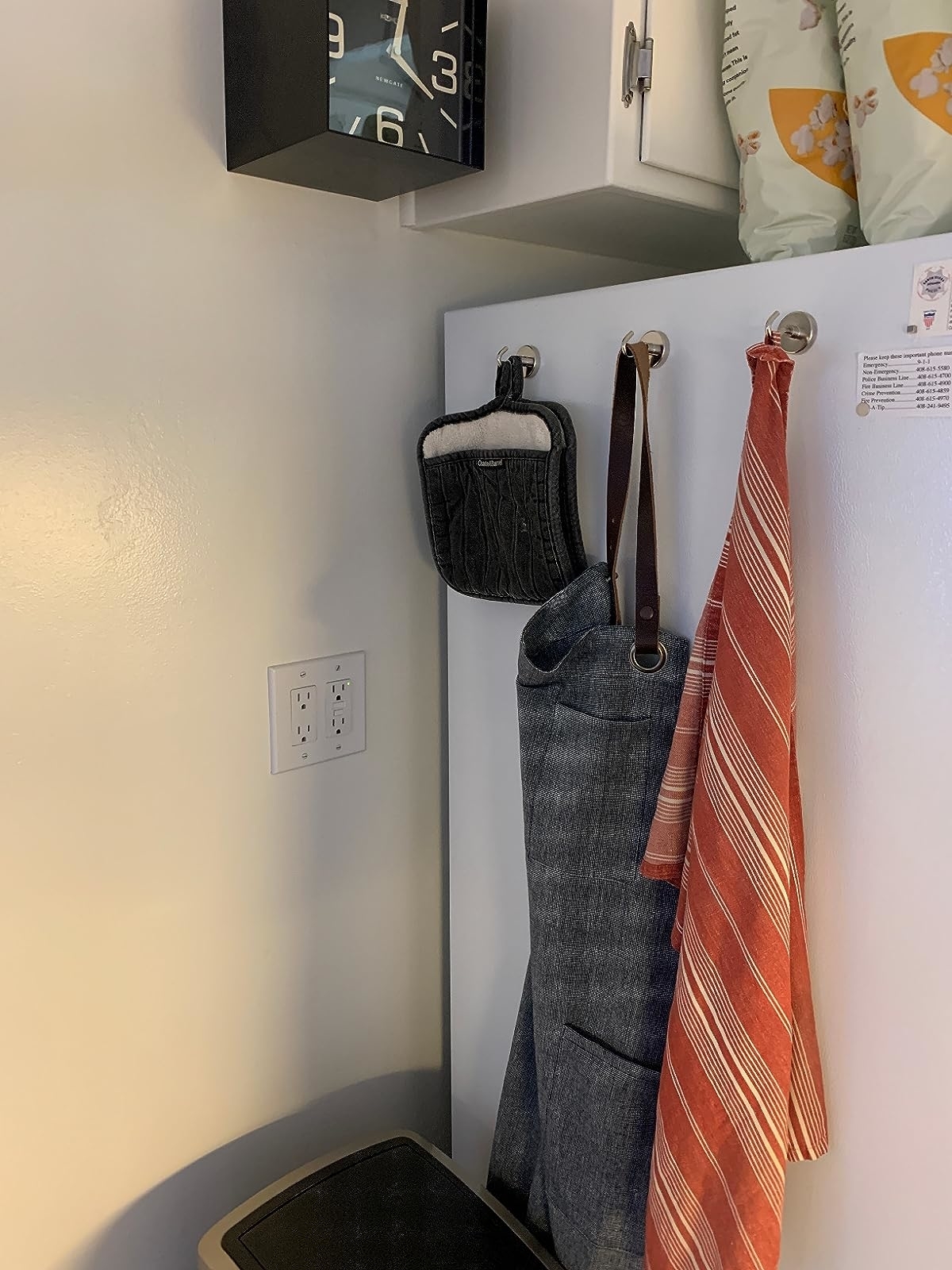 Reviewer image of hooks on their fridge holding aprons and pot holders