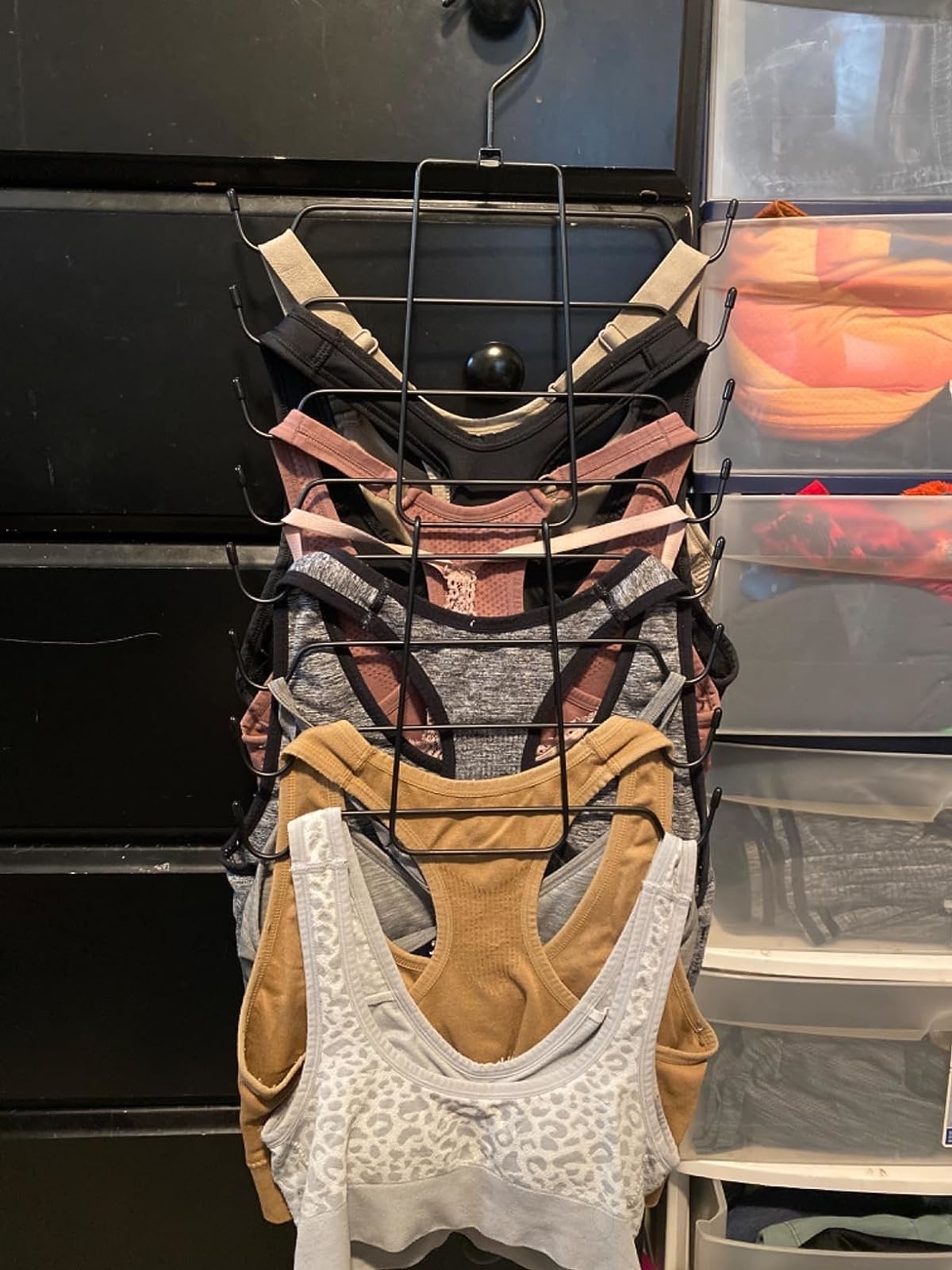 Reviewer image of sports bras hanging on organizer