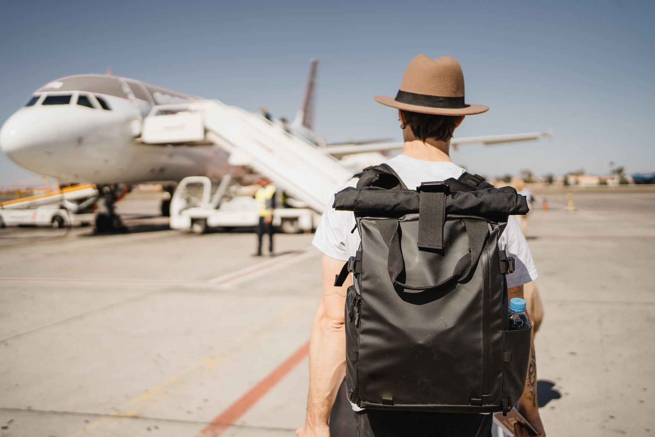 guy with a backpack headed to a plane