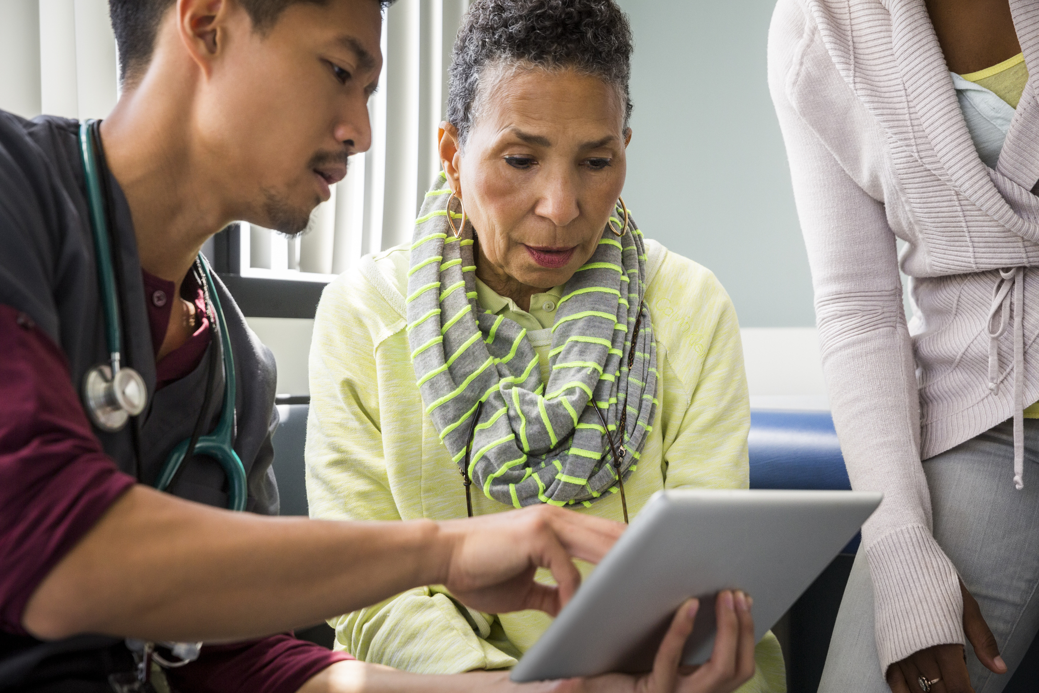 A doctor showing an older woman something on a tablet